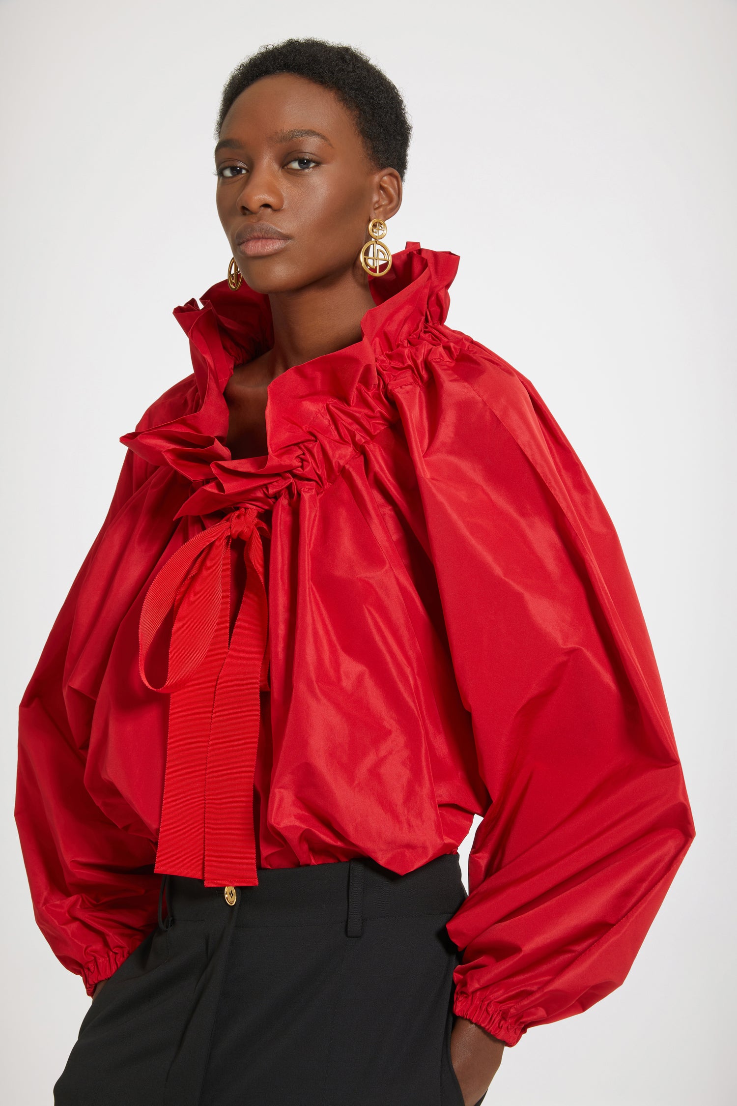 Patou - Haut à manches bouffantes en faille recyclée - Lipstick Red - Encolure fermée ou épaules dénudées ? Chez Patou on veut tout !Haut en faille recyclée rouge lipstick. Silhouette volumineuse. Col à coulisse avec détail de fronce et gros-grain. Manches chauve-souris resserrées aux poignets. Taille élastiquée.