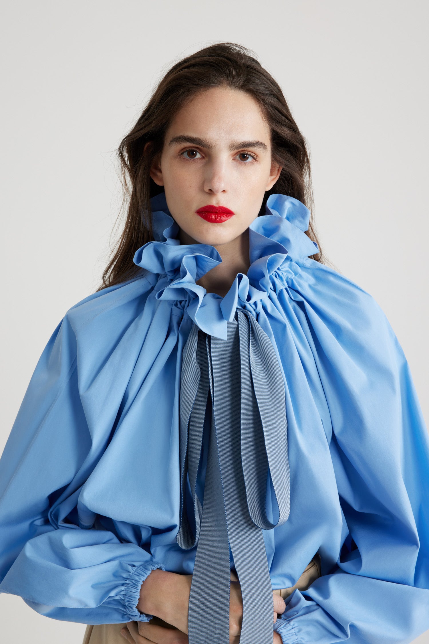 Patou - オーガニックコットン アイコニック ドローストリング トップス - Airy Blue - エアリーブルーのオーガニックコットンポプリン製トップ。ネックで結んでもオフショルダーでも着用可能なハイボリューム シルエット。フロントにフラウンスをあしらったドローストリングカラー、ロンググログランタイ付き。袖口に伸縮性があるバットウィングスリーブ。伸縮性があるウエスト。