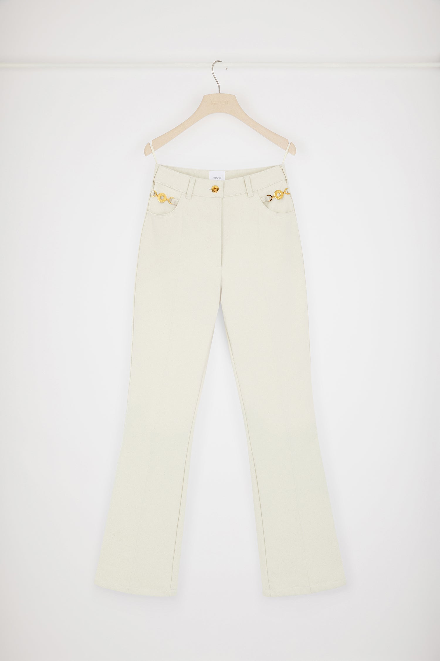 Patou - Flared trousers in regenerated cotton denim - Natural - Jean genie: denim by Patou.Natural ecru regenerated cotton denim trousers. Flared leg. Mid rise. Gold-tone Patou-engraved button at the front. Belt loops. Embroidered Patou logo at the waistband. Darts and central creases at the front and back. Two pockets at the front with gold-tone Patou-engraved ornaments. Signature curved seam at the back.This style is very fitted at the waist.