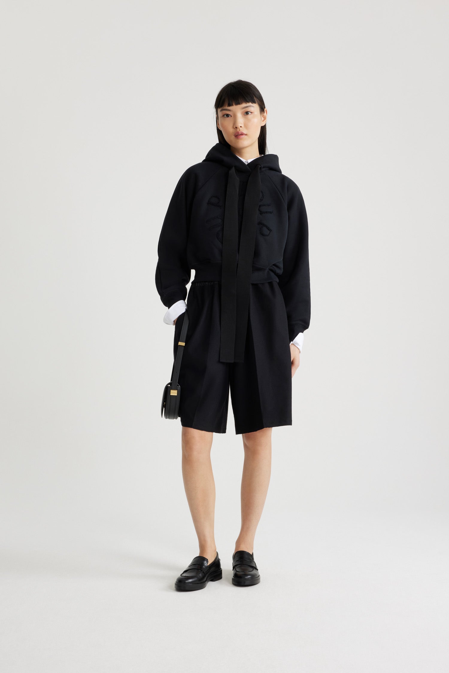Patou - Lang geschnittene Shorts aus nachhaltiger Wollmischung - Black - Schwarze Flanellshorts aus nachhaltiger Wollmischung. Knielang. Elastischer Taillenbund. Kontrastierender Bund. Zwei Seitentaschen. Bügelfalten auf der Vorderseite.