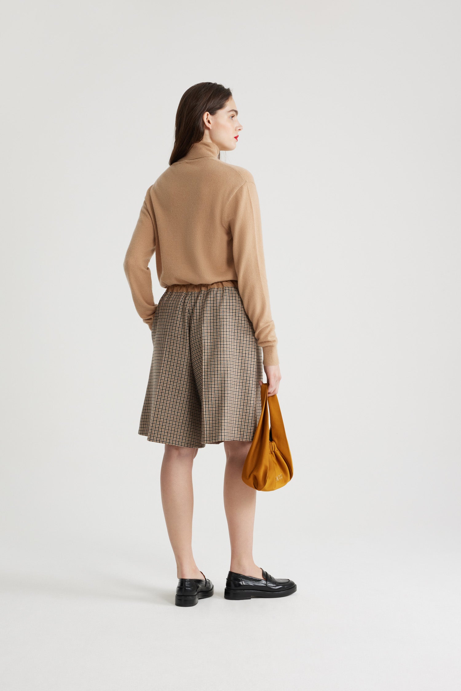 Patou - Longline shorts in recycled wool blend - Houndstooth - Recycled wool blend flannel shorts. Houndstooth pattern. Knee length. Elasticated waist. Contrast waistband. Two pockets at the sides. Pressed creases at the front.
