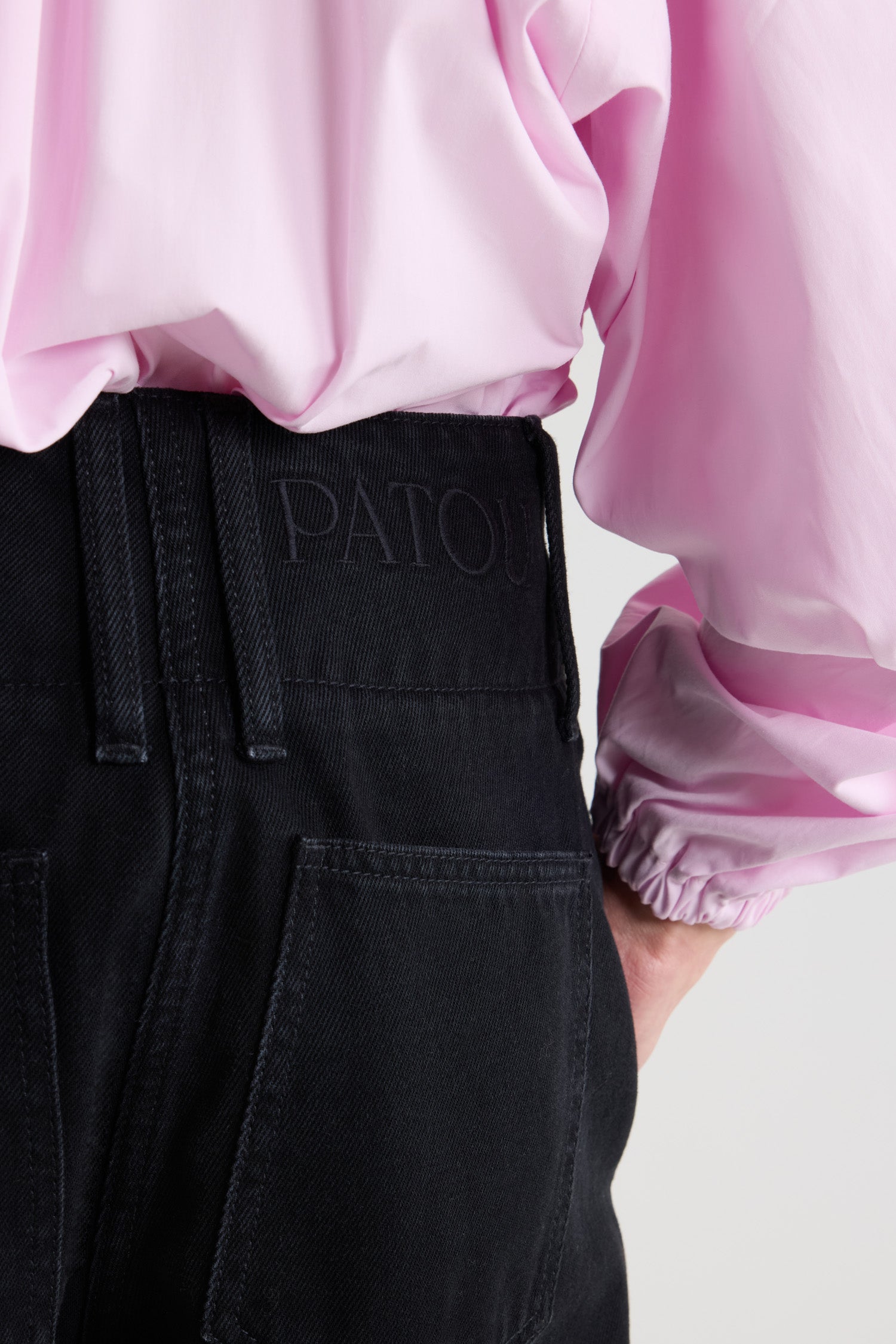 Patou - 오가닉 코튼 데님 와이드 웨이스트밴드 트라우저 - Khol Stone - 콜 스톤 블랙 컬러의 오가닉 코튼 데님 트라우저. 미드 - 로우 웨이스트. 스트레이트 컷 레그. 벨트 루프. 앞면의 골드 톤 파투 로고 인그레이빙 버튼 및 히든 지퍼. 측면 포켓. 앞면의 다림질한 주름.