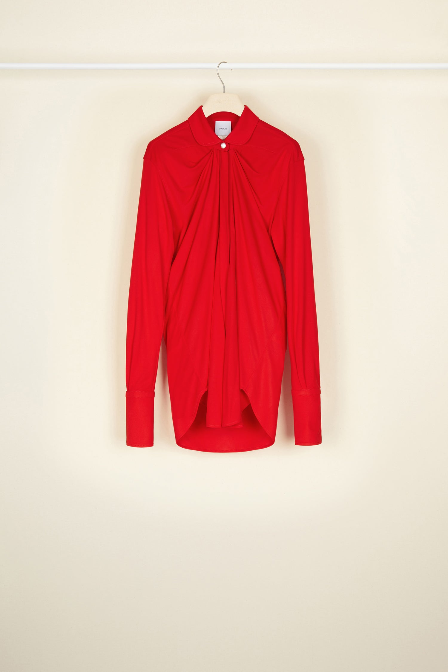 Patou - Blouse en jersey à col claudine - Poppy - Le col s’arrondit et s’affirme.Blouse longue en jersey rouge coquelicot. Un classique du répertoire Patou revisité avec un col claudine. Silhouette drapée. Bouton en nacre au col, gorge cachée et boutons aux poignets.