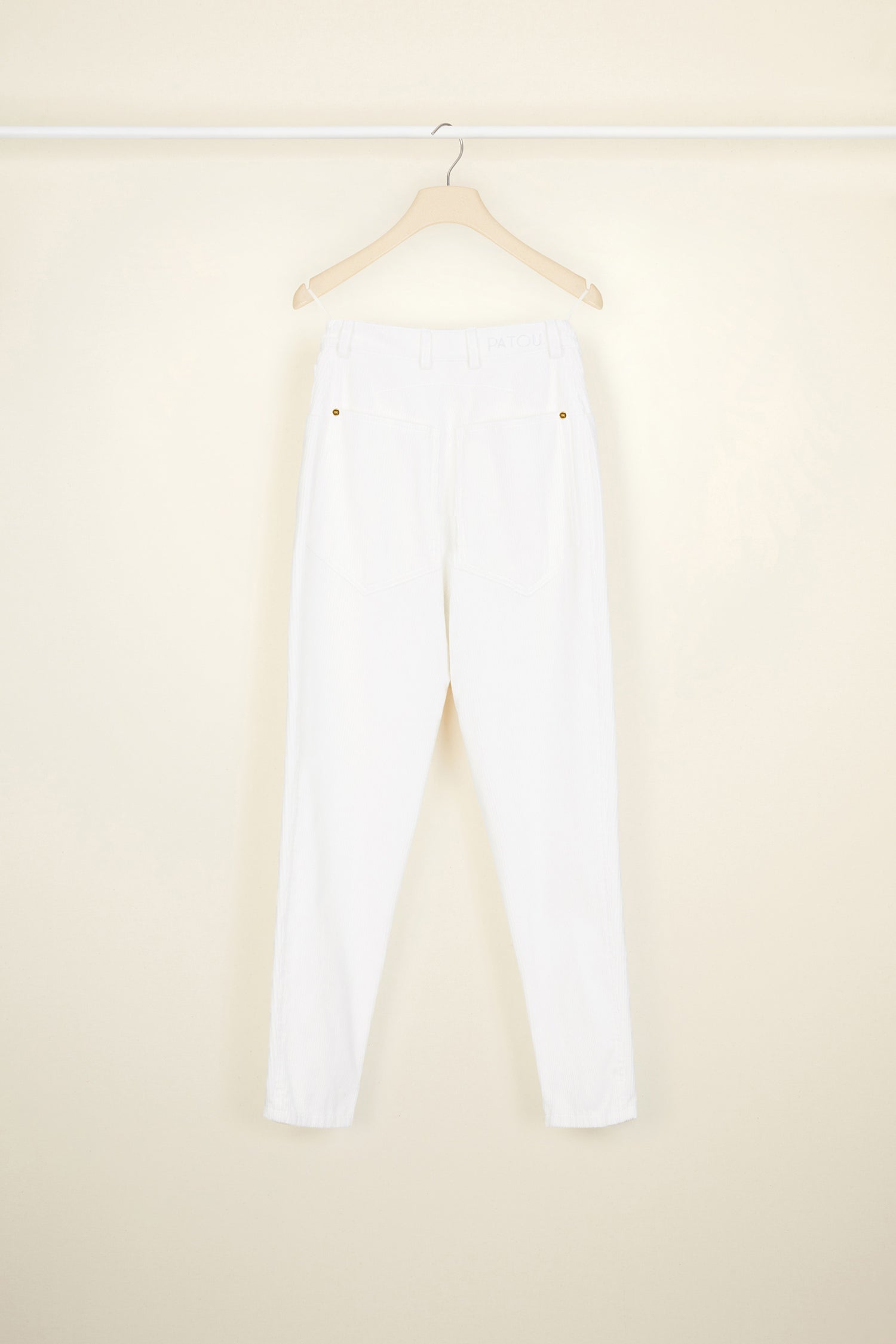 Patou - Corduroy carrot trousers - Pearl - A novel direction for everyday trousers.A new tapered silhouette in pearl white corduroy. Five-pocket style with gold-coloured hardware. Button and zip fastening at the front. Belt loops. Embroidered lettering logo and signature dart at the back.