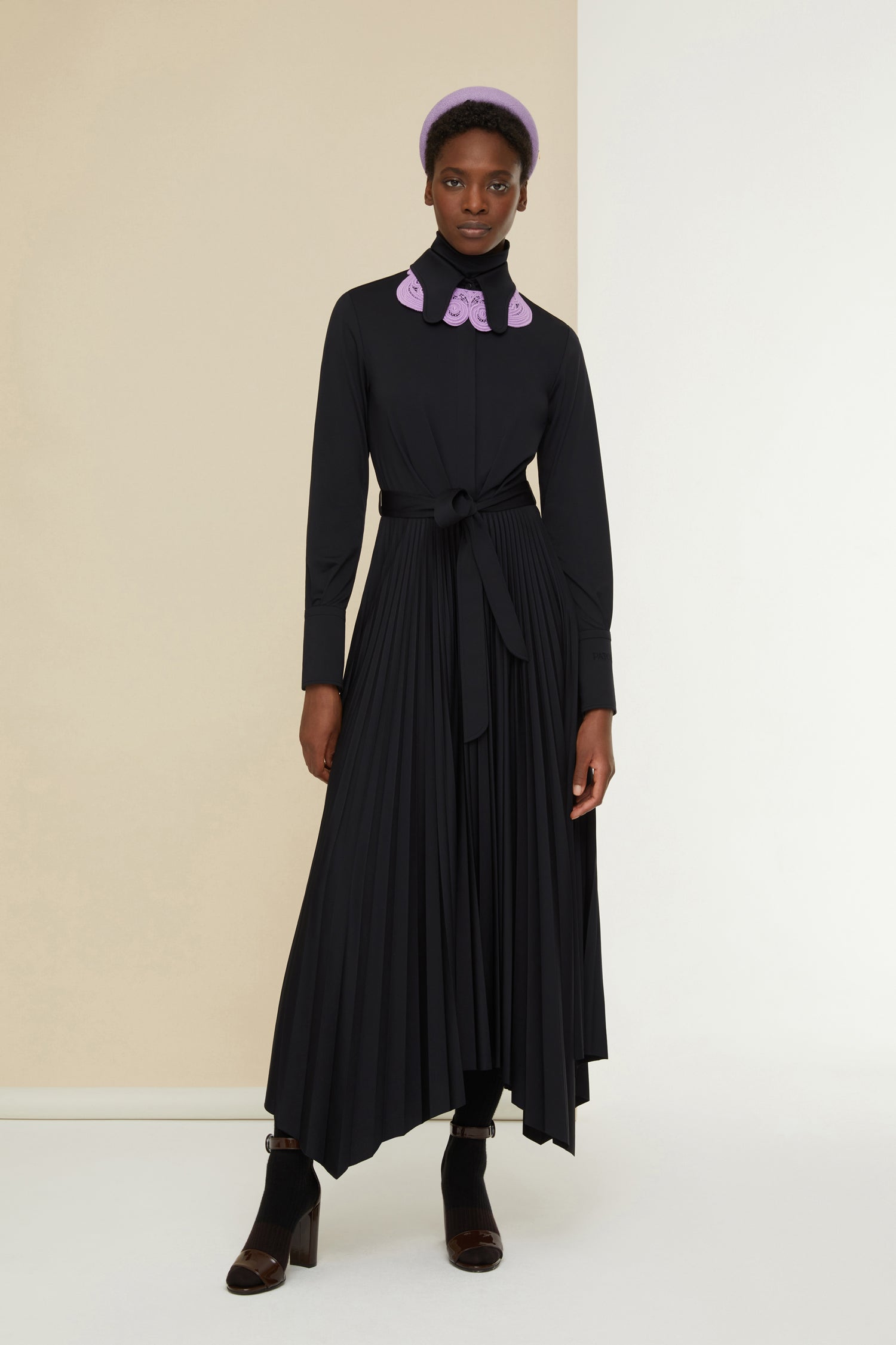 Patou - Maxi pleated shirt dress in eco-friendly jersey - Black - Belted and pleated, a silhouette-defining moment. Black recycled stretch jersey dress. Butterfly collar. Concealed button fastening. Box pleats on the bodice. Fabric belt at the waist. Wide cuffs with embroidered Patou logo and buttons. Asymmetrical maxi skirt with sunpleats.