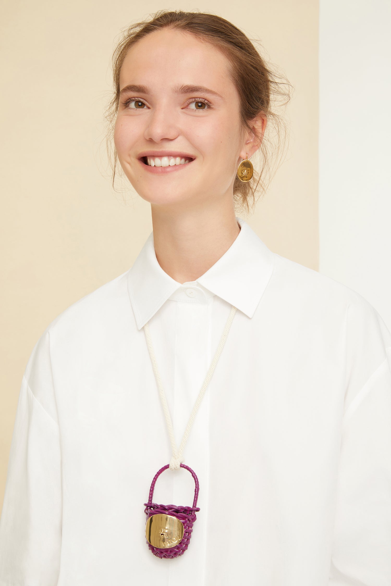 Patou - Bucket bag necklace in wicker - Anemone - A shiny amulet to carry your Patou everywhere with you. Ecru cord necklace with miniature wicker bucket bag pendant in Anemone purple. Top handle with a sliding lid. Gold-tone embellishment inspired by the Bocca della Verità"."