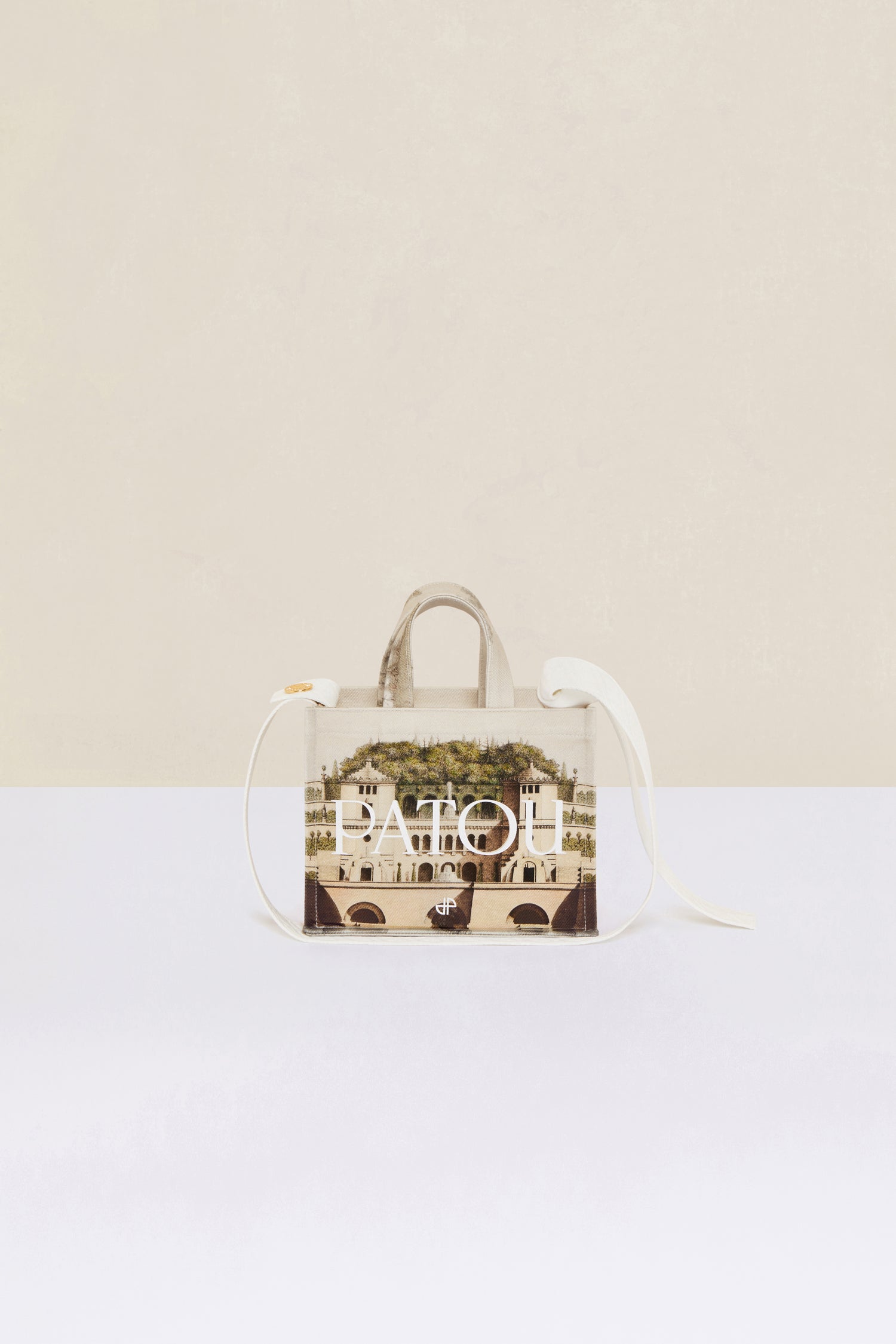 Patou - Small Patou canvas tote in printed organic cotton - Amour Island - A little Patou goes a long way.Organic cotton tote featuring Jean-Jacques Lequeu's “Amour Island” print. Patou lettering logo and JP monogram in white. White embossed shoulder strap with gold button on one side and adjustable knot on the other side. Two tone-on-tone top handles. Can be carried by hand or on the shoulder.