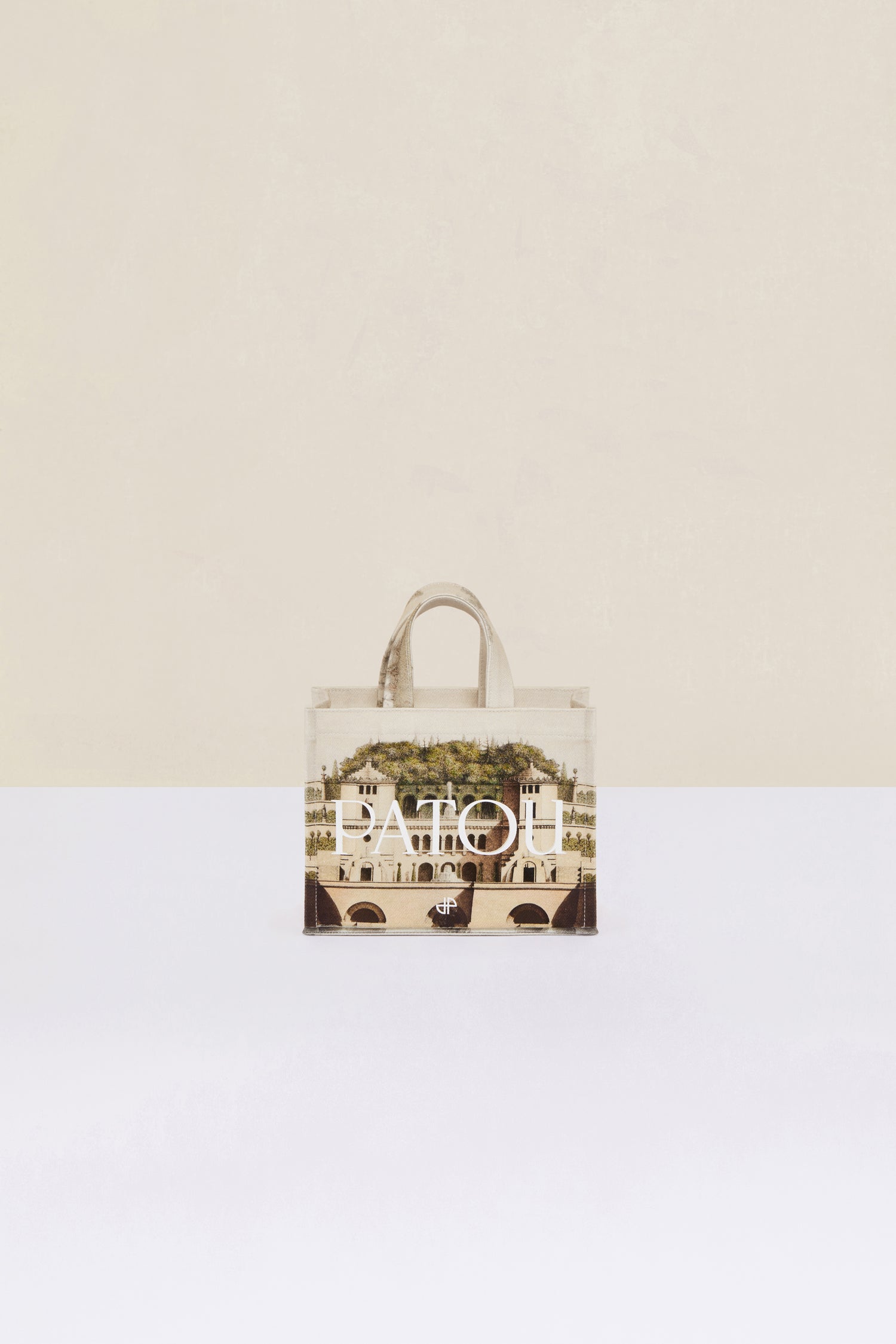Patou - Small Patou canvas tote in printed organic cotton - Amour Island - A little Patou goes a long way.Organic cotton tote featuring Jean-Jacques Lequeu's “Amour Island” print. Patou lettering logo and JP monogram in white. White embossed shoulder strap with gold button on one side and adjustable knot on the other side. Two tone-on-tone top handles. Can be carried by hand or on the shoulder.