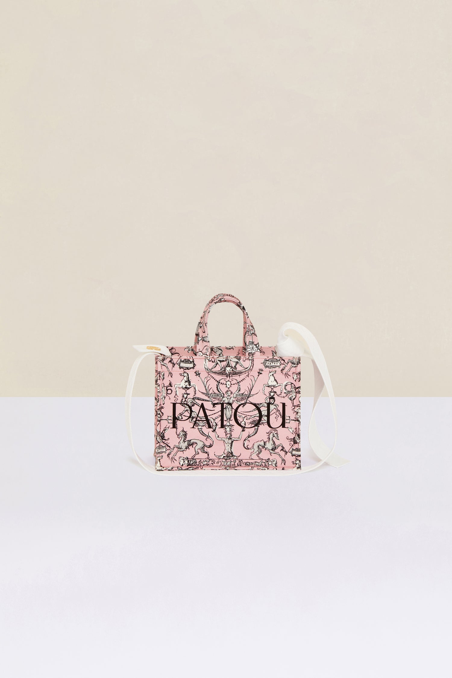 Patou - Small Patou canvas tote in printed organic cotton - Pink Fairy Tales - A tale of organic canvas and magical prints.Pink organic cotton tote. “Stories and Tales” seasonal print. Patou lettering logo and JP monogram in black. White embossed shoulder strap with gold button on one side and adjustable knot on the other side. Two tone-on-tone top handles. Can be carried by hand or on the shoulder.