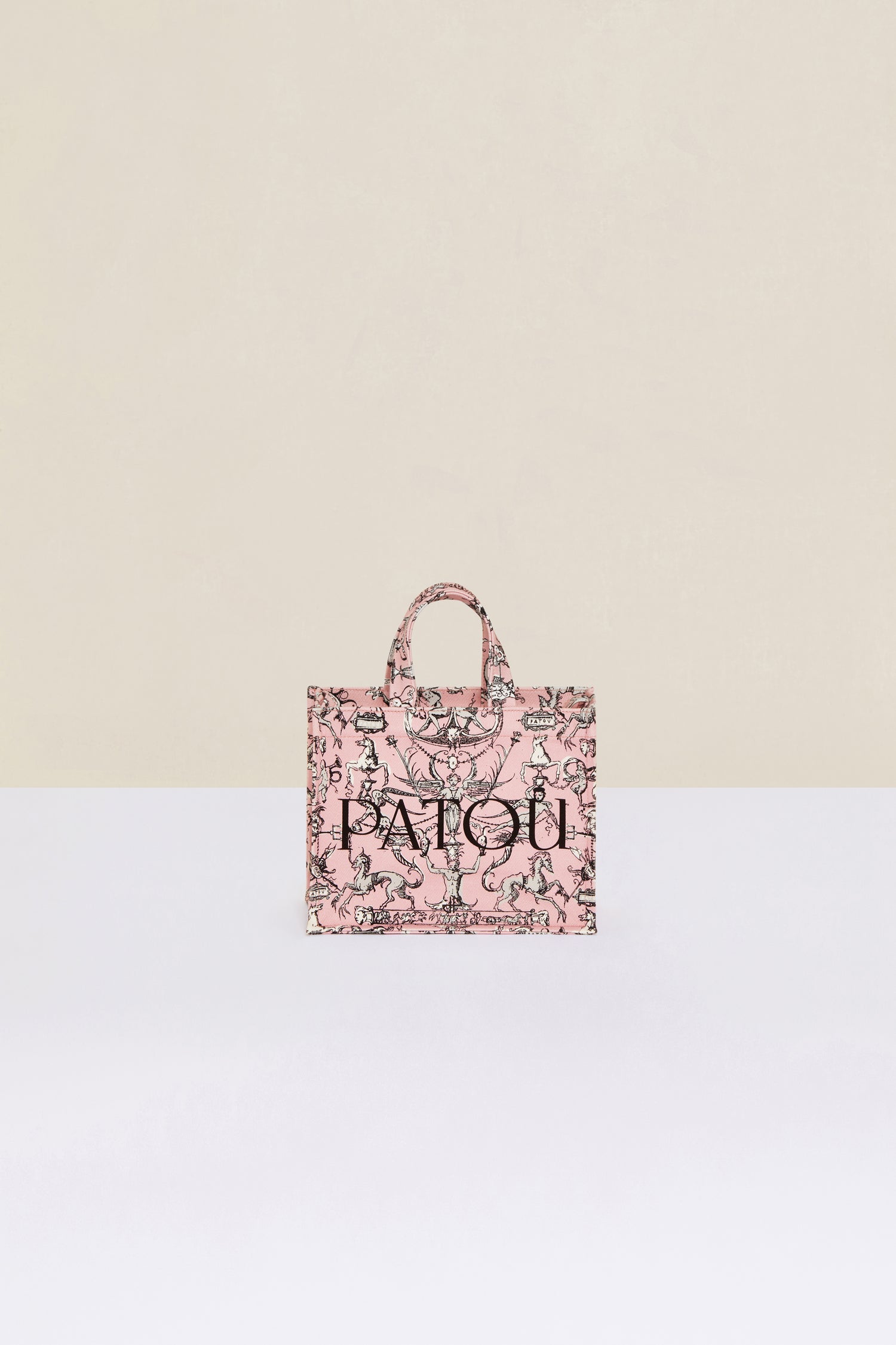 Patou - Small Patou canvas tote in printed organic cotton - Pink Fairy Tales - A tale of organic canvas and magical prints.Pink organic cotton tote. “Stories and Tales” seasonal print. Patou lettering logo and JP monogram in black. White embossed shoulder strap with gold button on one side and adjustable knot on the other side. Two tone-on-tone top handles. Can be carried by hand or on the shoulder.