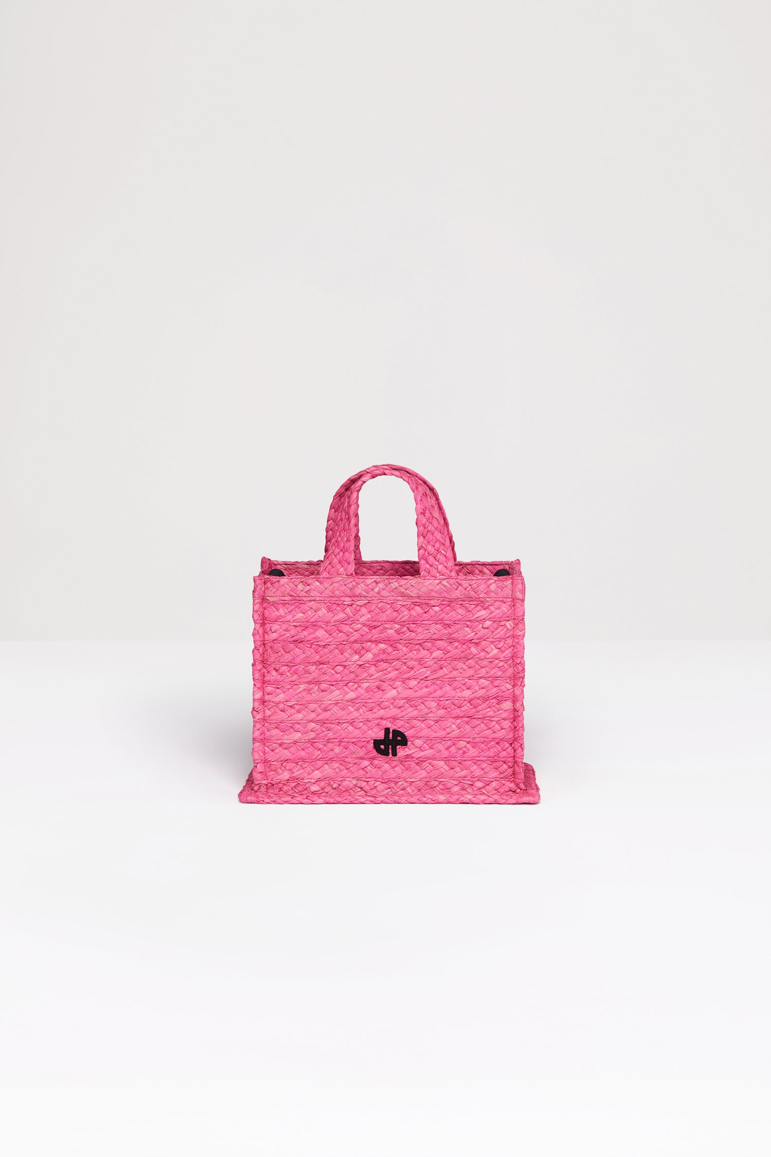 Patou - Small JP tote in raffia - Begonia Pink - A summer classic infused with Patou magic.Begonia pink raffia tote. JP monogram in black at the front. Black embossed canvas shoulder strap with gold buttons. Two top handles. Can be carried by hand or on the shoulder.
