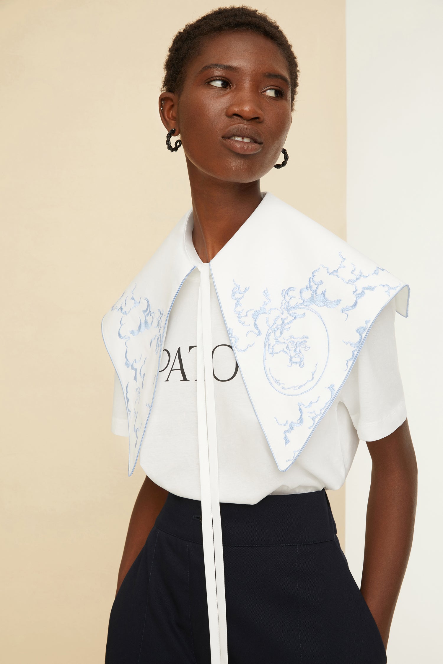 Patou - Col brodé en coton bio - White - La broderie tout en fantaisie.Col en coton bio blanc brodé de motifs inspirés de la “Bocca della Verità”. Modèle oversize à bouts pointus. Fermeture par lacets à l’avant.