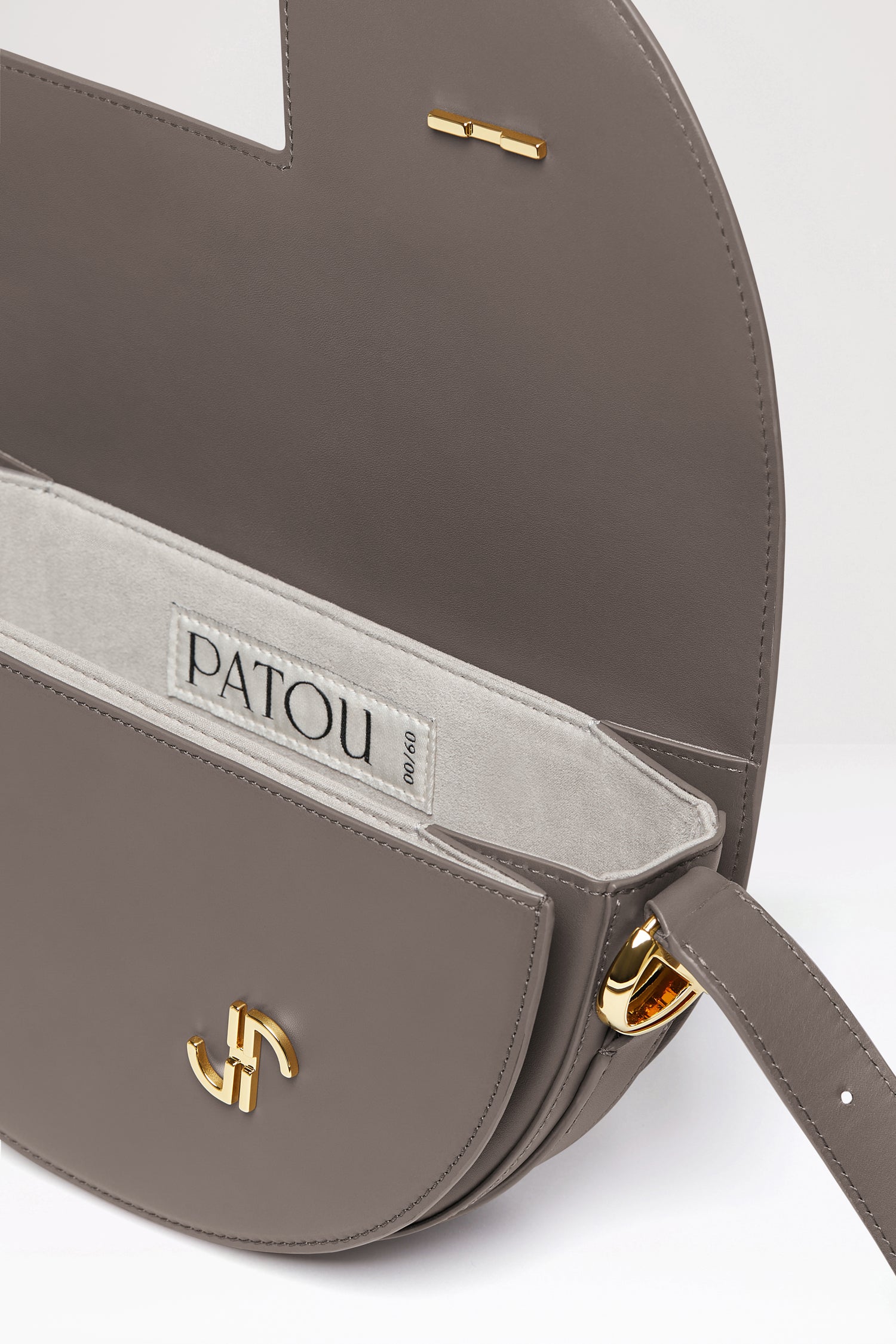 Patou - Le Patou ロゴバッグ - Storm - バッグを超えたパトゥ バッグ!ストームグレーのレザーハンドバッグ。未使用レザーから持続可能な方法により調達した独自の素材で作られた限定エディション。番号入り60点限定エディション。JPモノグラムにインスピレーションを得た幾何学的なカットアウトをあしらった半円形のフォルム。サイドにゴールドトーンのメタルパーツとJPモノグラム ディテール。調整可能なストラップで、ショルダーバッグ、クロスボディバッグ、ハンドバッグとしてお使いいただけます。ゴールドトーンのJPディテールをあしらったマグネットクロージャー。内部に複数のコンパートメント。長さ: 25cm 高さ:15cm 幅: 6cmストラップの長さは3段階で調節可能:47 cm (ショルダー)、36 cm (クロスボディ)、28 cm (ハンド)。