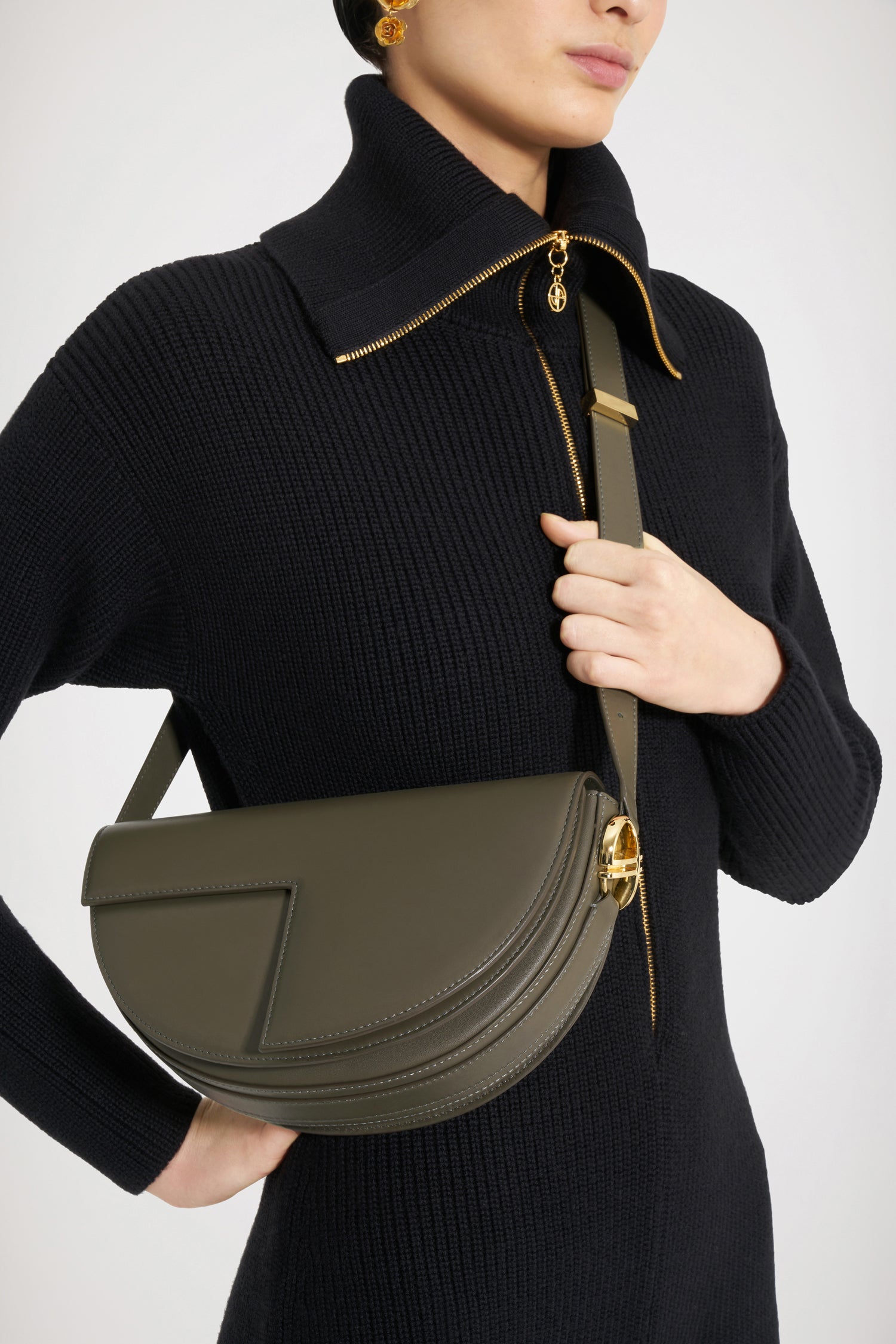 Patou - Le Patou バッグ - Winter Moss - バッグを超えたパトゥ バッグ!ウィンターモスグリーンのレザーハンドバッグ。未使用レザーから持続可能な方法により調達した独自の素材で作られた限定エディション。番号入り40 点限定エディション。JPモノグラムにインスピレーションを得た幾何学的なカットアウトをあしらった半円形のフォルム。サイドにゴールドトーンのメタルパーツとJPモノグラム ディテール。調整可能なストラップで、ショルダーバッグ、クロスボディバッグ、ハンドバッグとしてお使いいただけます。ゴールドトーンのJPディテールをあしらったマグネットクロージャー。内部に複数のコンパートメント。エコライニング。長さ: 25 cm高さ: 15 cm幅:6 cmストラップの長さは3段階で調節可能:47 cm (ショルダー)、36 cm (クロスボディ)、28 cm (ハンド)