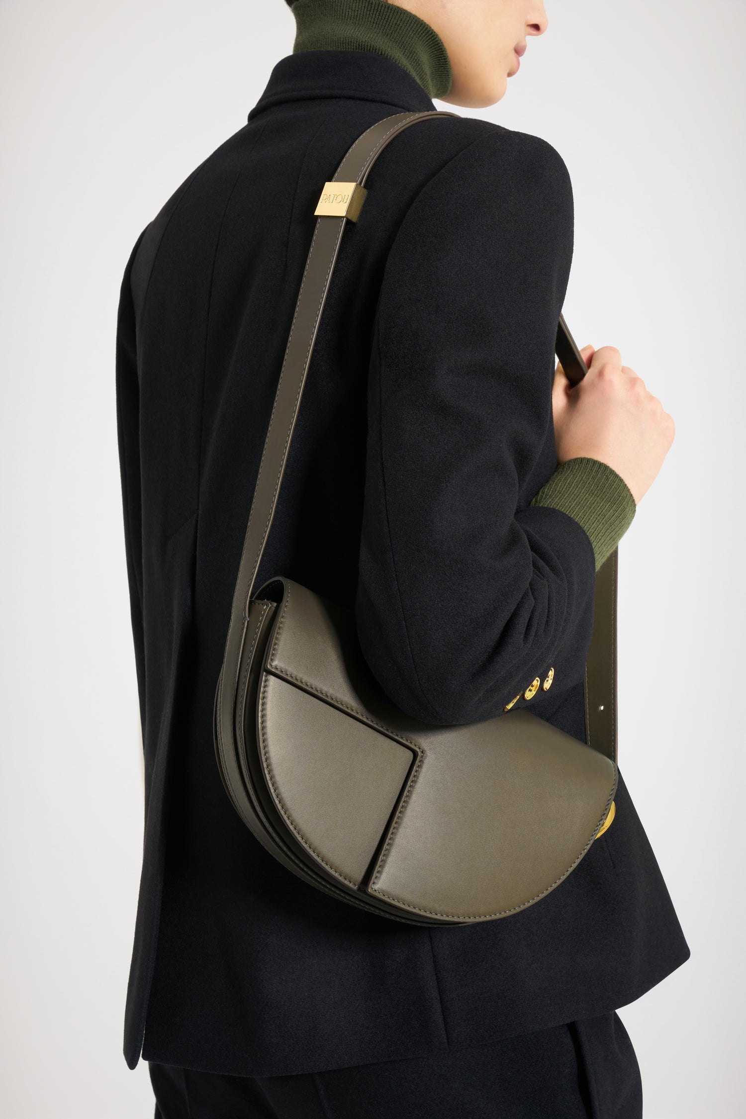 Patou - Le Patou バッグ - Winter Moss - バッグを超えたパトゥ バッグ!ウィンターモスグリーンのレザーハンドバッグ。未使用レザーから持続可能な方法により調達した独自の素材で作られた限定エディション。番号入り40 点限定エディション。JPモノグラムにインスピレーションを得た幾何学的なカットアウトをあしらった半円形のフォルム。サイドにゴールドトーンのメタルパーツとJPモノグラム ディテール。調整可能なストラップで、ショルダーバッグ、クロスボディバッグ、ハンドバッグとしてお使いいただけます。ゴールドトーンのJPディテールをあしらったマグネットクロージャー。内部に複数のコンパートメント。エコライニング。長さ: 25 cm高さ: 15 cm幅:6 cmストラップの長さは3段階で調節可能:47 cm (ショルダー)、36 cm (クロスボディ)、28 cm (ハンド)