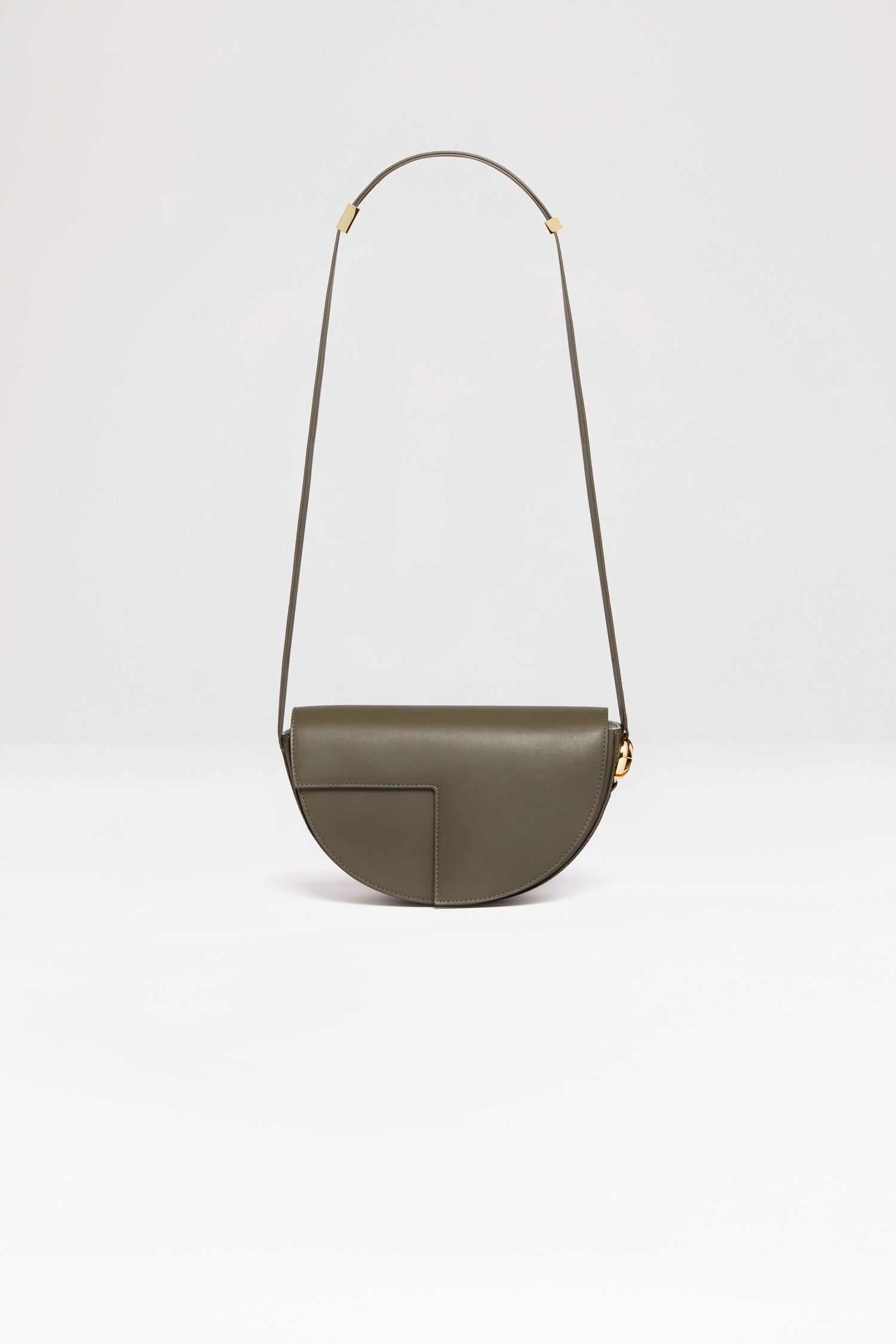 Patou - Le Patou バッグ - Winter Moss - バッグを超えたパトゥ バッグ!ウィンターモスグリーンのレザーハンドバッグ。未使用レザーから持続可能な方法により調達した独自の素材で作られた限定エディション。番号入り40 点限定エディション。JPモノグラムにインスピレーションを得た幾何学的なカットアウトをあしらった半円形のフォルム。サイドにゴールドトーンのメタルパーツとJPモノグラム ディテール。調整可能なストラップで、ショルダーバッグ、クロスボディバッグ、ハンドバッグとしてお使いいただけます。ゴールドトーンのJPディテールをあしらったマグネットクロージャー。内部に複数のコンパートメント。エコライニング。長さ: 25 cm高さ: 15 cm幅:6 cmストラップの長さは3段階で調節可能:47 cm (ショルダー)、36 cm (クロスボディ)、28 cm (ハンド)