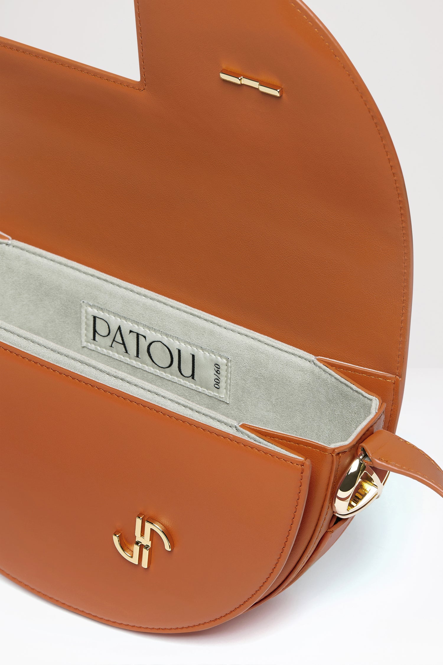 Patou - Borsa Le Patou - Saffron Clay - Conosci Le Patou? La nuova borsa cult in tutti i colori che ami di più.Borsa in pelle color argilla zafferano.Realizzata con pellami recuperati dal ciclo di produzione. Edizione limitata e numerata di 200 esemplari. Forma a mezzaluna con tagli geometrici ispirati al monogramma JP. Pezzi in metallo oro con dettaglio JP ispirato a una spilla dell'archivio Jean Patou. Tracolla regolabile che permette di indossarla in più modi: in spalla, crossbody o a mano. Chiusura magnetica con dettaglio JP oro. Compartimenti interni multipli. Fodera in eco camoscio.Dimensioni : lunghezza: 25 cm; altezza: 15 cm; larghezza: 6 cmTracolla regolabile con tre lunghezze: 47 cm (sulla spalla), 36 cm (crossbody), 28 cm (a mano).