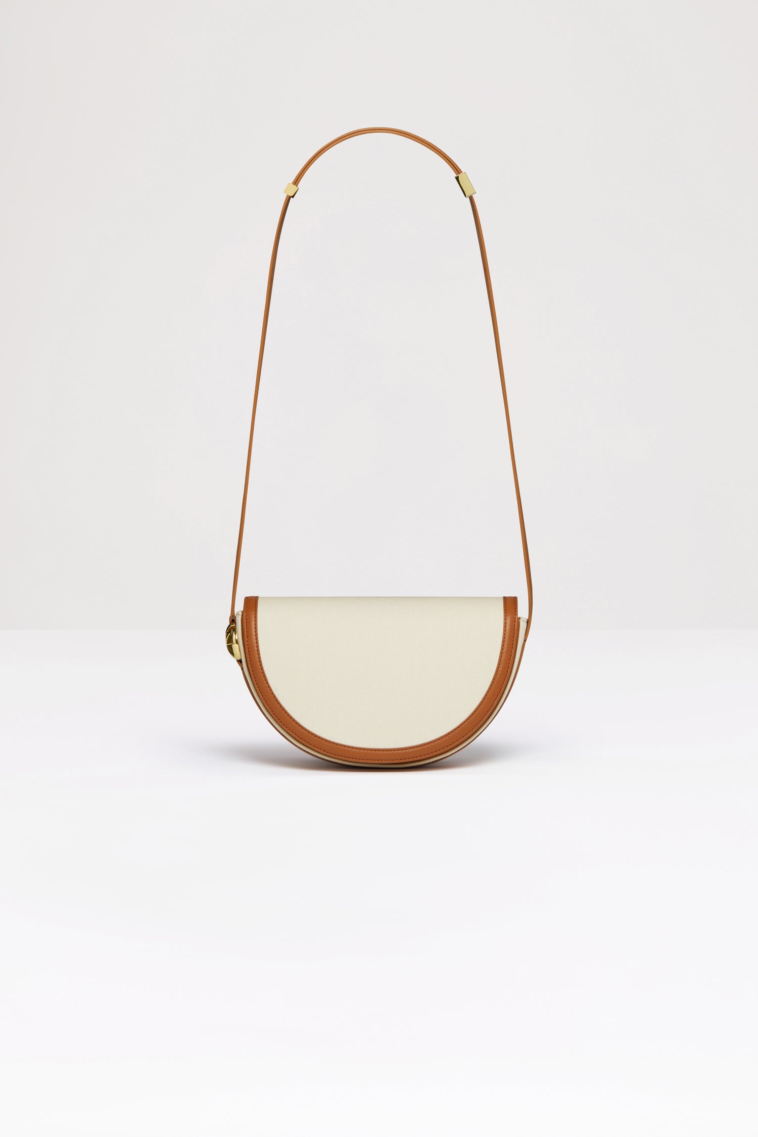 Patou - Le Patou bag in recycled cotton and leather - Saffron Clay - A new take on Le Patou that is bound to delight you. Natural recycled cotton canvas and Saffron Clay brown leather handbag. All leather parts sourced from unused high quality leather hides. 120 limited numbered edition. Half-circle shape with geometric cut-outs inspired by the JP monogram. Gold-tone hardware with JP monogram detail at the side. Adjustable strap that allows it to be worn on the shoulder, across the body or carried by hand. Magnetic closure with gold-tone JP detail. Multiple compartments inside.Measures: 25cm (length), 15cm (height), 6cm (depth)3 lengths for the adjustable strap: 47 cm (on the shoulder), 36 cm (across the body), 28 cm (carried by hand).