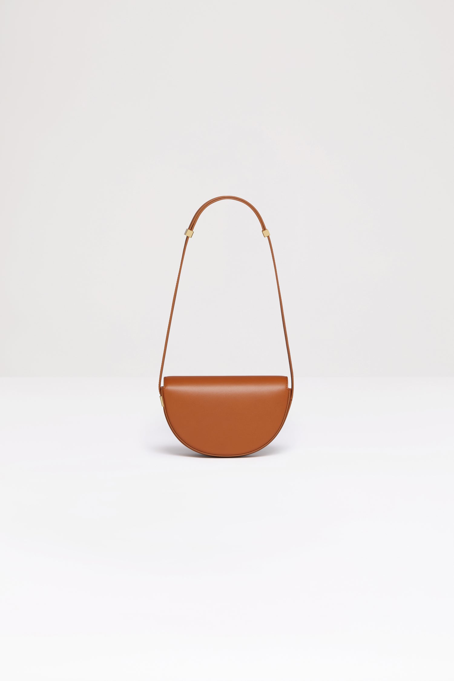 Patou - Le Petit Patou - Saffron Clay - A smaller take on everyone's favourite piece of Patou!Saffron Clay tan leather handbag. Crafted using unique materials sourced from unused high quality leather hides. 120 limited numbered edition. Half-circle shape with geometric cut-outs inspired by the JP monogram. Gold-tone hardware with JP monogram detail at the side. Adjustable strap that allows it to be worn on the shoulder, across the body or carried by hand. Magnetic closure with gold-tone JP detail. Multiple compartments inside. Eco lining.Measures: 20cm (length), 13cm (height), 5cm (depth)