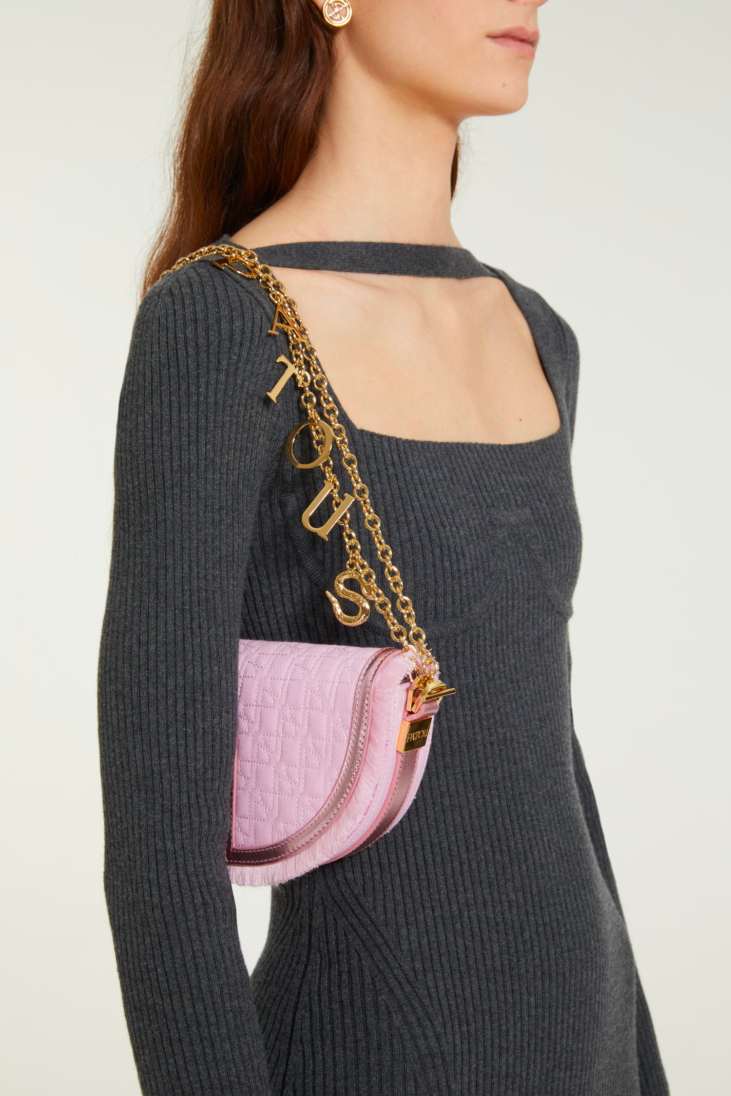 Patou - Le Petit Patou x Sita - Pink - Remixé et revisité, le Petit Patou plus culte que jamais !Sac en coton bio recyclé effet denim et cuir métallisé rose. Créé dans le cadre de la collaboration spéciale avec la DJ et styliste Sita Abellán. Réalisé en cuir de grande qualité provenant de stocks dormants issus des surplus de production. Forme demi-lune avec découpes géométriques inspirée du monogramme JP. Surpiqûres JP. Pièce métallique dorée gravée Patou sur le côté. Bordure soulignée de cuir avec détail de franges. Bandoulière en cuir amovible ornée d'un serpent, symbole signature de Sita, permettant au sac d'être porté sur l'épaule ou à la main. Peut être remplacée par une bandoulière en laiton (vendue séparément) ornée des lettres Patou et du serpent emblématique de Sita pour un porté épaule, en bandoulière ou à la taille afin de transformer Le Petit Patou en sac ceinture. Fermeture aimantée avec détail JP doré. Doublure éco-friendly. Dimensions : 20 cm de longueur, 13 cm de hauteur et 5 cm de profondeur.