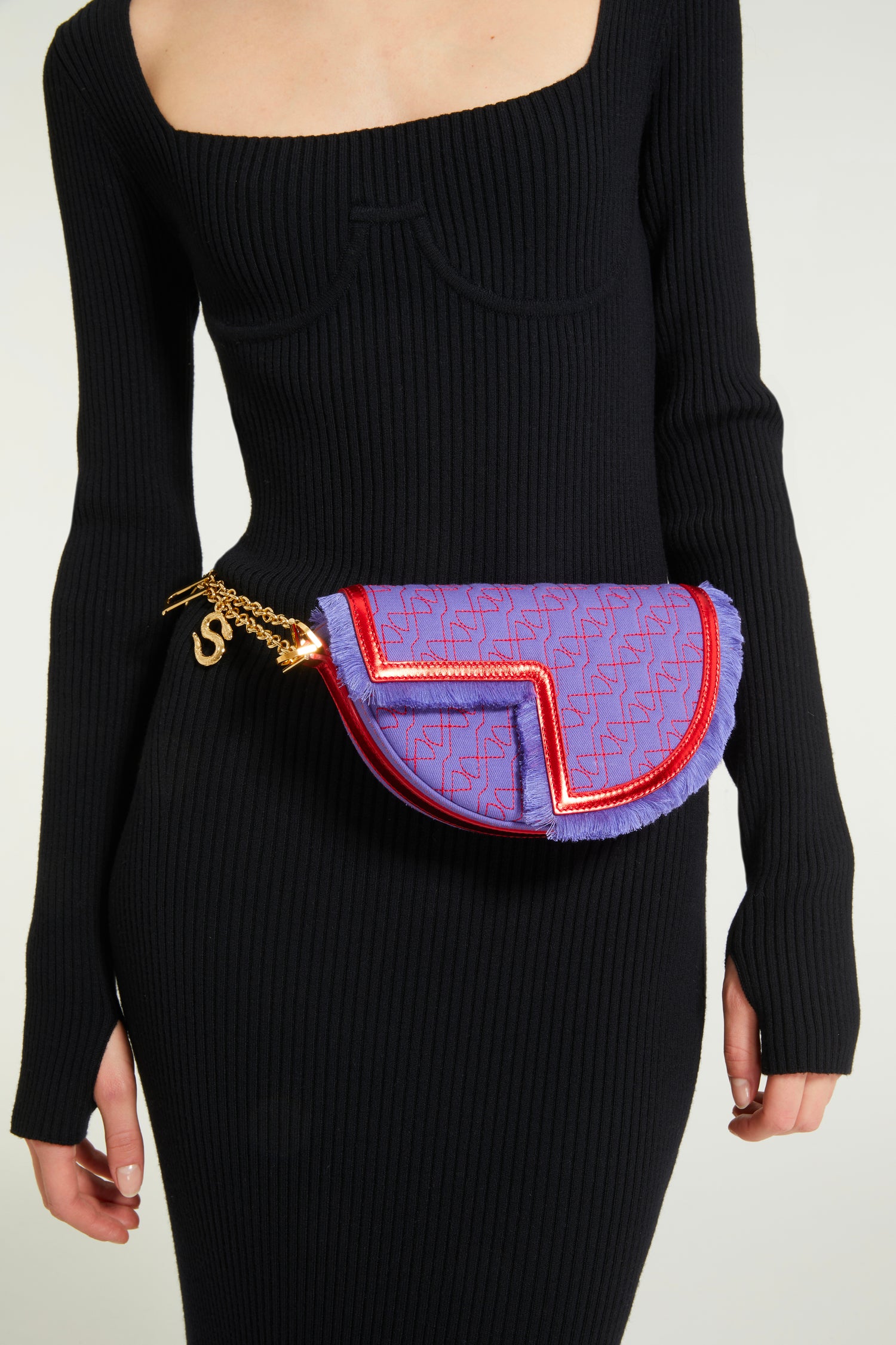 Patou - Le Petit Patou x Sita - Purple Blue Red - A high-octane remix on a Patou favouriteViolet denim-effect recycled organic cotton and red metallic leather handbag. Part of a special collaboration with DJ and designer Sita Abellán. Crafted using premium deadstock leather. Half-circle shape with geometric cut-outs inspired by the JP monogram. Allover JP quilting in red. Gold-tone hardware with Patou-engraved detail at the side. Leather outline with fringed edges. Removable leather strap adorned with Sita's signature snake that allows it to be worn on the shoulder or carried by hand. Might be replaced by a gold-tone brass chain strap (sold separately) adorned with Patou letter charms and Sita's snake symbol; the chain can be used as single or double length and worn on the shoulder, across the body or at the waist to turn Le Petit Patou into a belt bag. Magnetic closure with gold-tone JP detail. Internal compartment. Eco lining.Measures: 20cm (length), 13cm (height), 5cm (depth)