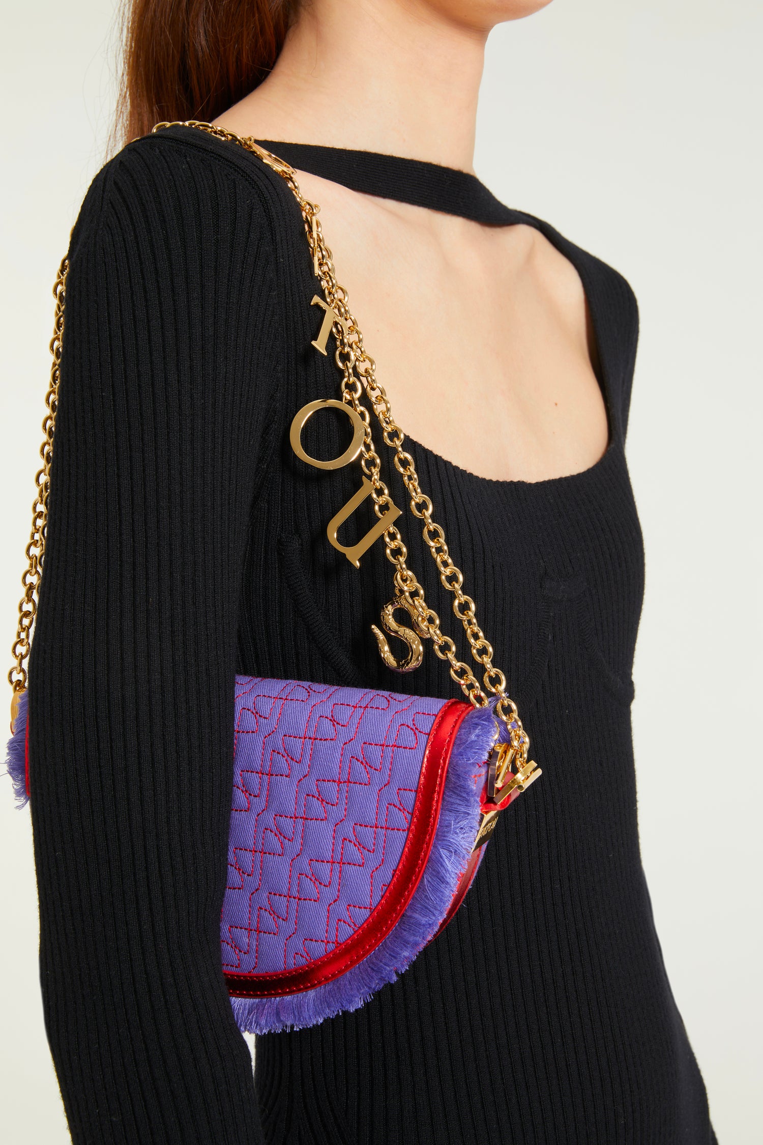 Patou - Le Petit Patou x Sita - Purple Blue Red - A high-octane remix on a Patou favouriteViolet denim-effect recycled organic cotton and red metallic leather handbag. Part of a special collaboration with DJ and designer Sita Abellán. Crafted using premium deadstock leather. Half-circle shape with geometric cut-outs inspired by the JP monogram. Allover JP quilting in red. Gold-tone hardware with Patou-engraved detail at the side. Leather outline with fringed edges. Removable leather strap adorned with Sita's signature snake that allows it to be worn on the shoulder or carried by hand. Might be replaced by a gold-tone brass chain strap (sold separately) adorned with Patou letter charms and Sita's snake symbol; the chain can be used as single or double length and worn on the shoulder, across the body or at the waist to turn Le Petit Patou into a belt bag. Magnetic closure with gold-tone JP detail. Internal compartment. Eco lining.Measures: 20cm (length), 13cm (height), 5cm (depth)
