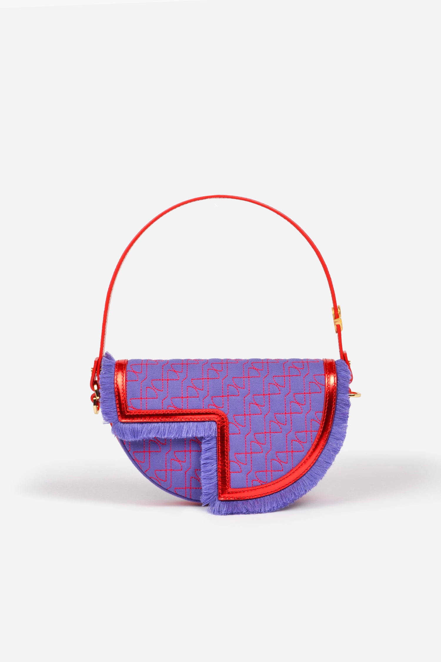 Patou - Le Petit Patou x Sita - Purple Blue Red - A high-octane remix on a Patou favouriteViolet denim-effect recycled organic cotton and red metallic leather handbag. Part of a special collaboration with DJ and designer Sita Abellán. Crafted using premium deadstock leather. Half-circle shape with geometric cut-outs inspired by the JP monogram. Allover JP quilting in red. Gold-tone hardware with Patou-engraved detail at the side. Leather outline with fringed edges. Removable leather strap adorned with Sita's signature snake that allows it to be worn on the shoulder or carried by hand. Might be replaced by a gold-tone brass chain strap (sold separately) adorned with Patou letter charms and Sita's snake symbol; the chain can be used as single or double length and worn on the shoulder, across the body or at the waist to turn Le Petit Patou into a belt bag. Magnetic closure with gold-tone JP detail. Internal compartment. Eco lining.Measures: 20cm (length), 13cm (height), 5cm (depth)