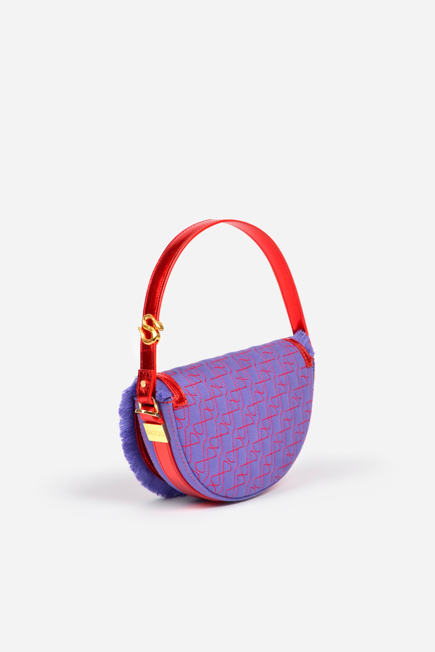 Patou - Le Petit Patou x Sita - Purple Blue Red - A high-octane remix on a Patou favouriteViolet denim-effect recycled organic cotton and red metallic leather handbag. Part of a special collaboration with DJ and designer Sita Abellán. Crafted using premium deadstock leather. Half-circle shape with geometric cut-outs inspired by the JP monogram. Allover JP quilting in red. Gold-tone hardware with Patou-engraved detail at the side. Leather outline with fringed edges. Removable leather strap adorned with Sita's signature snake that allows it to be worn on the shoulder or carried by hand. Might be replaced by a gold-tone brass chain strap (sold separately) adorned with Patou letter charms and Sita's snake symbol; the chain can be used as single or double length and worn on the shoulder, across the body or at the waist to turn Le Petit Patou into a belt bag. Magnetic closure with gold-tone JP detail. Internal compartment. Eco lining.Measures: 20cm (length), 13cm (height), 5cm (depth)
