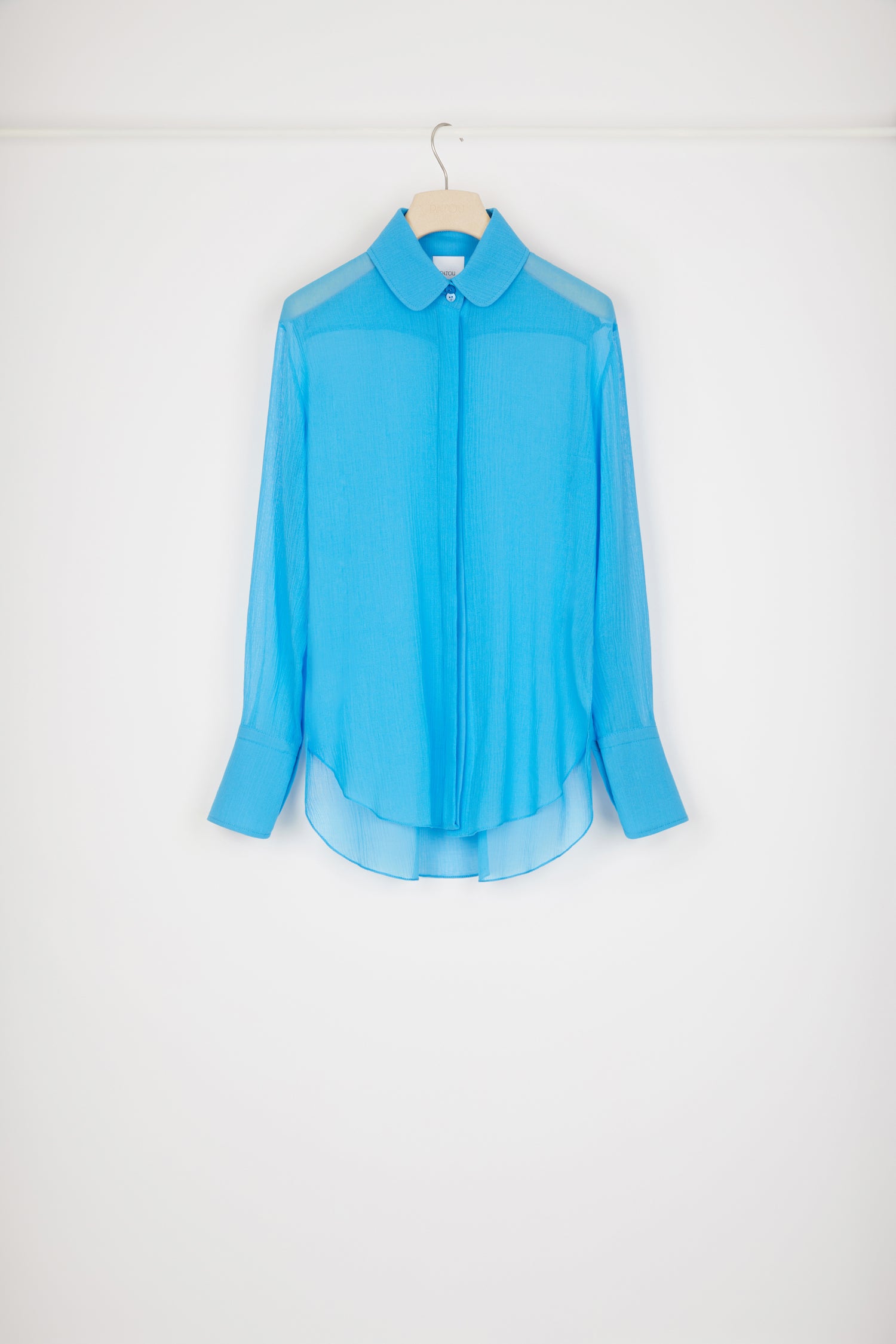 Patou - オーガニックコットン製シアーシャツ - Blue Jewel - シアーなデザインがセンセーショナルなパトゥシャツの新バージョン。ブルージュエルカラーのオーガニックコットン製シャツ。軽量のクレープ地が繊細な透け感を演出します。ピーターパンカラー。隠しボタンプラケット。袖口にボタン付き。バックにブランドを象徴するカーブシーム。