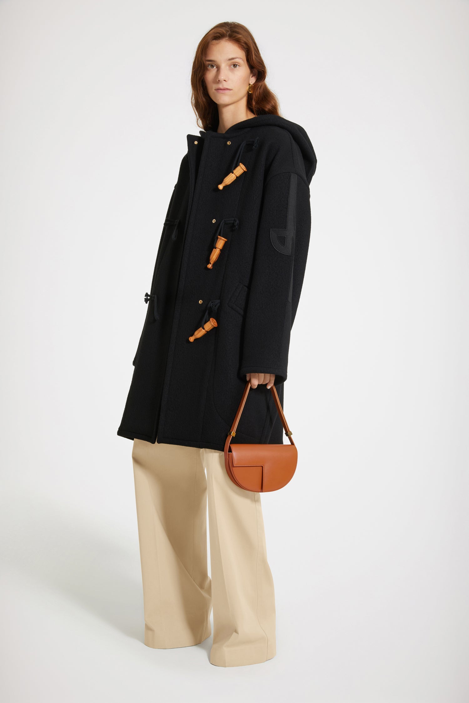 Patou - Cashmere and wool blend duffle coat - Black - Wool and whistles.Black cashmere and wool duffle coat. Crafted from recycled materials blended to achieve a softly worn look over time. Oversized silhouette. Hooded collar. Fastens via wooden buttons shaped like bird calls as well as concealed press buttons. Stylised JP logo embroidered in black on the left sleeve. Oversized patch pockets.