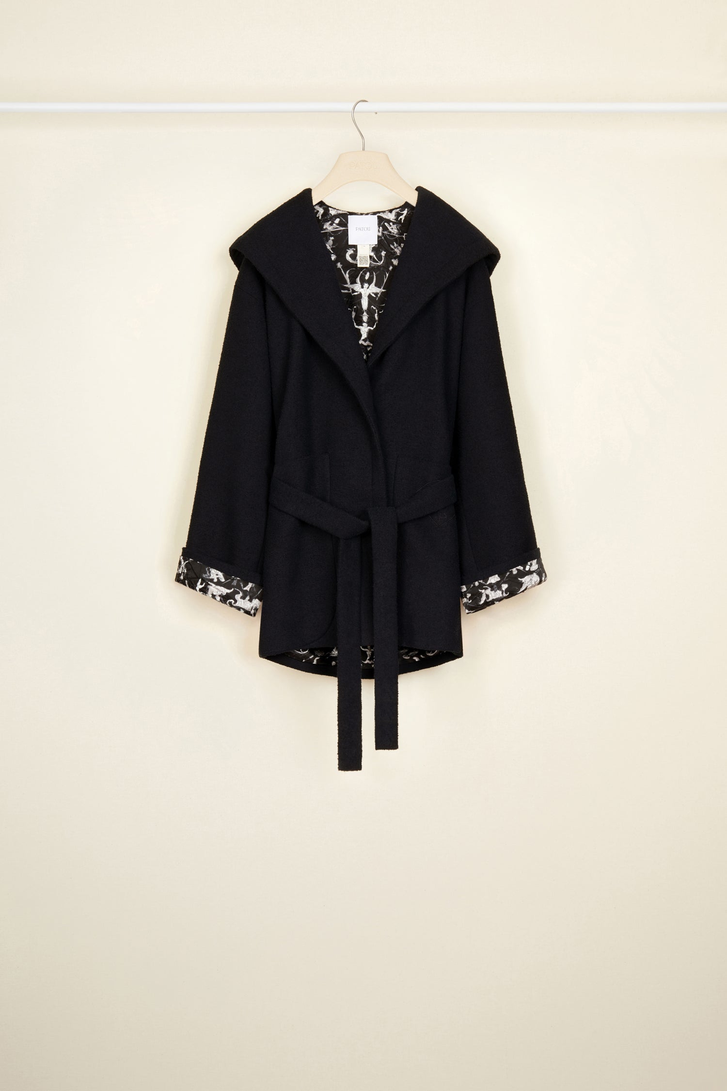 Patou - Belted robe coat in cotton blend bouclé - Black - Laidback bouclé to keep you smiling all day. Black cotton blend summer bouclette coat. Robe silhouette with oversized hooded collar and wide lapels. Concealed button fastening. Belt at the waist. Two patch pockets at the front. Patou lettering logo and JP monogram embroidered on the left pocket. Black "Stories and Tales" printed lining in organic twill satin.