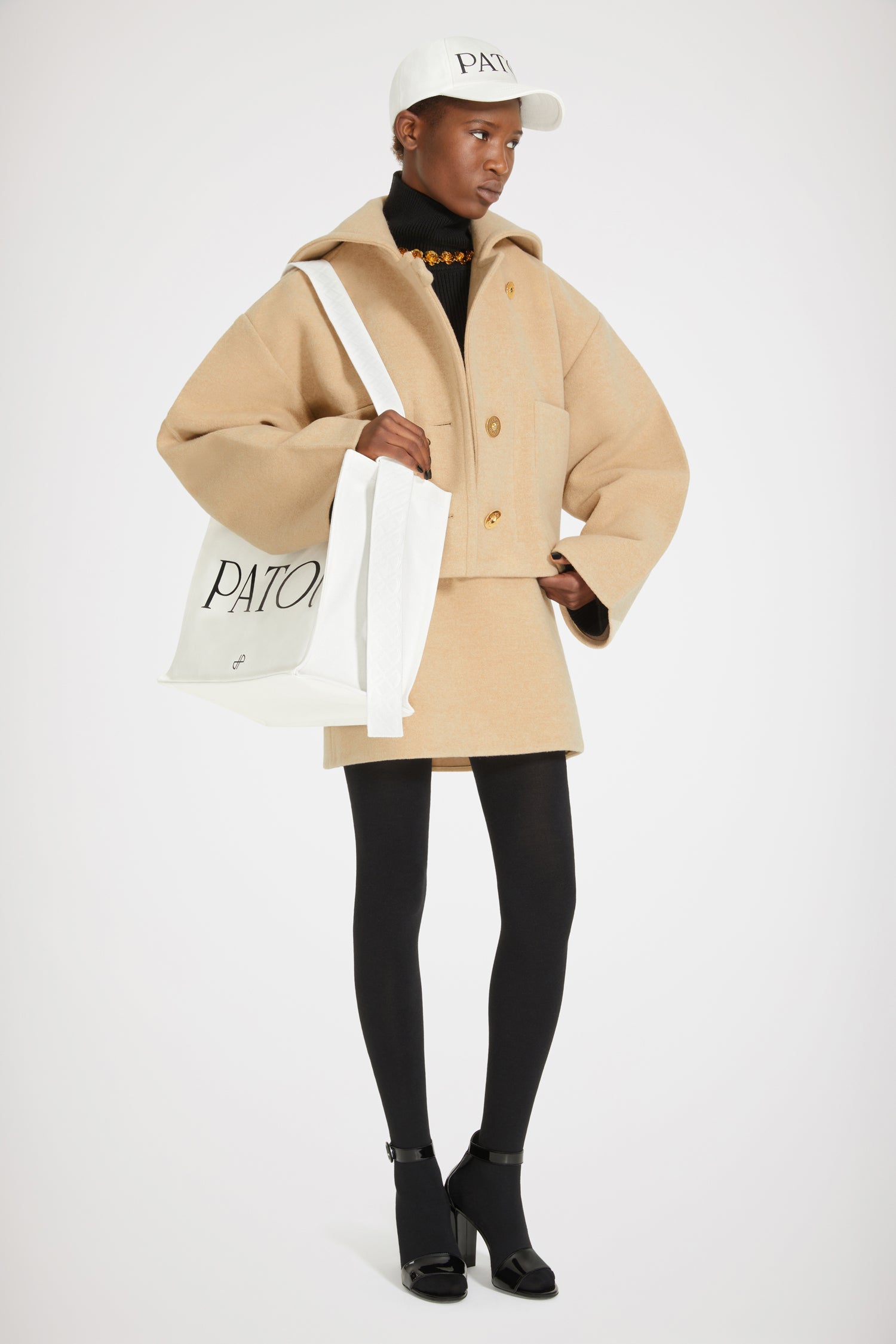 Patou - Manteau court en laine double face - Biscuit - La laine double face mise sur le court.Manteau en laine double face beige biscuit. Coupe courte. Modèle droit avec boutonnage décentré sur l’avant. Boutons dorés gravés Patou. Col style vareuse brodé Patou au dos. Maxi poches plaquées. Coupe loose (pour une coupe plus ajustée : prendre une taille en-dessous de votre taille habituelle).