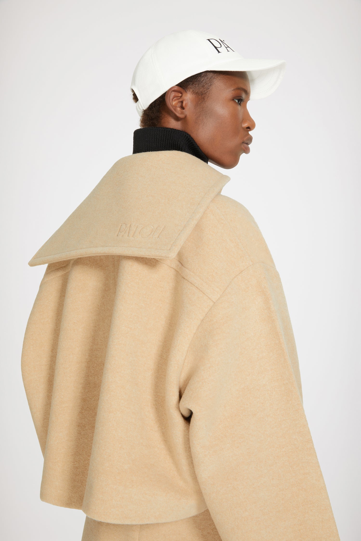 Patou - Manteau court en laine double face - Biscuit - La laine double face mise sur le court.Manteau en laine double face beige biscuit. Coupe courte. Modèle droit avec boutonnage décentré sur l’avant. Boutons dorés gravés Patou. Col style vareuse brodé Patou au dos. Maxi poches plaquées. Coupe loose (pour une coupe plus ajustée : prendre une taille en-dessous de votre taille habituelle).