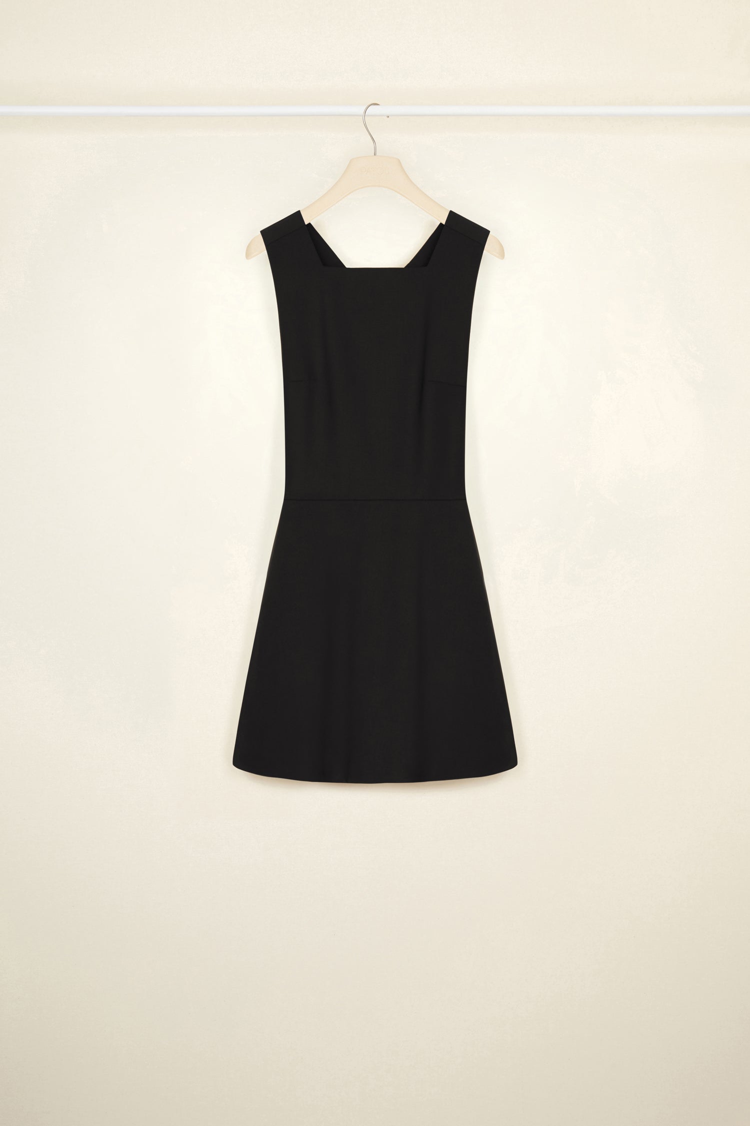 Patou - Pinafore mini dress in wool - Black - A pretty pinafore that is so much more!Black stretch wool dress. Short length. Fit and flare silhouette. Curved neckline. Wide straps that button at the back. Wide adjustable belt at the back. Pleated skirt. Seam pockets.