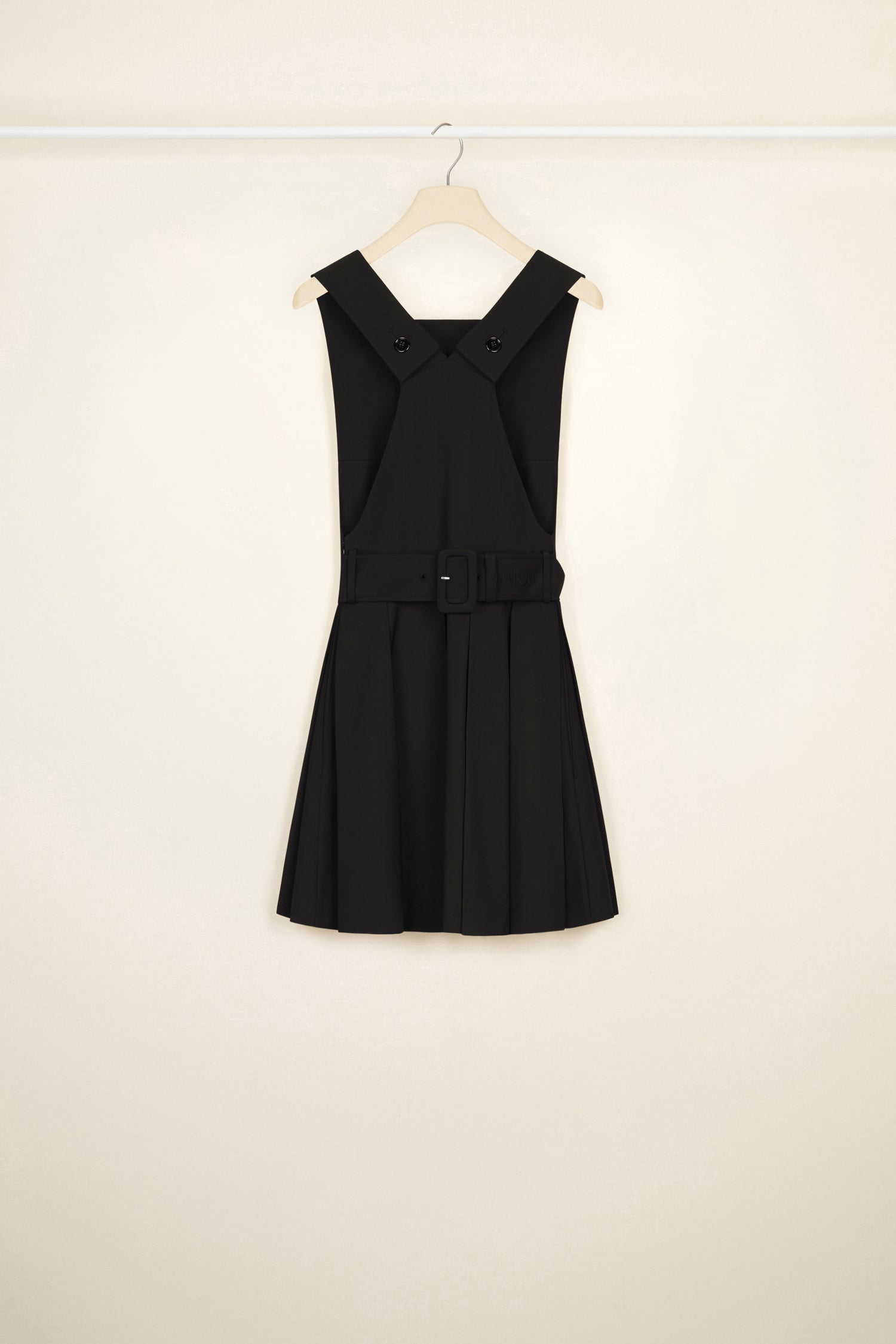 Patou - Pinafore mini dress in wool - Black - A pretty pinafore that is so much more!Black stretch wool dress. Short length. Fit and flare silhouette. Curved neckline. Wide straps that button at the back. Wide adjustable belt at the back. Pleated skirt. Seam pockets.