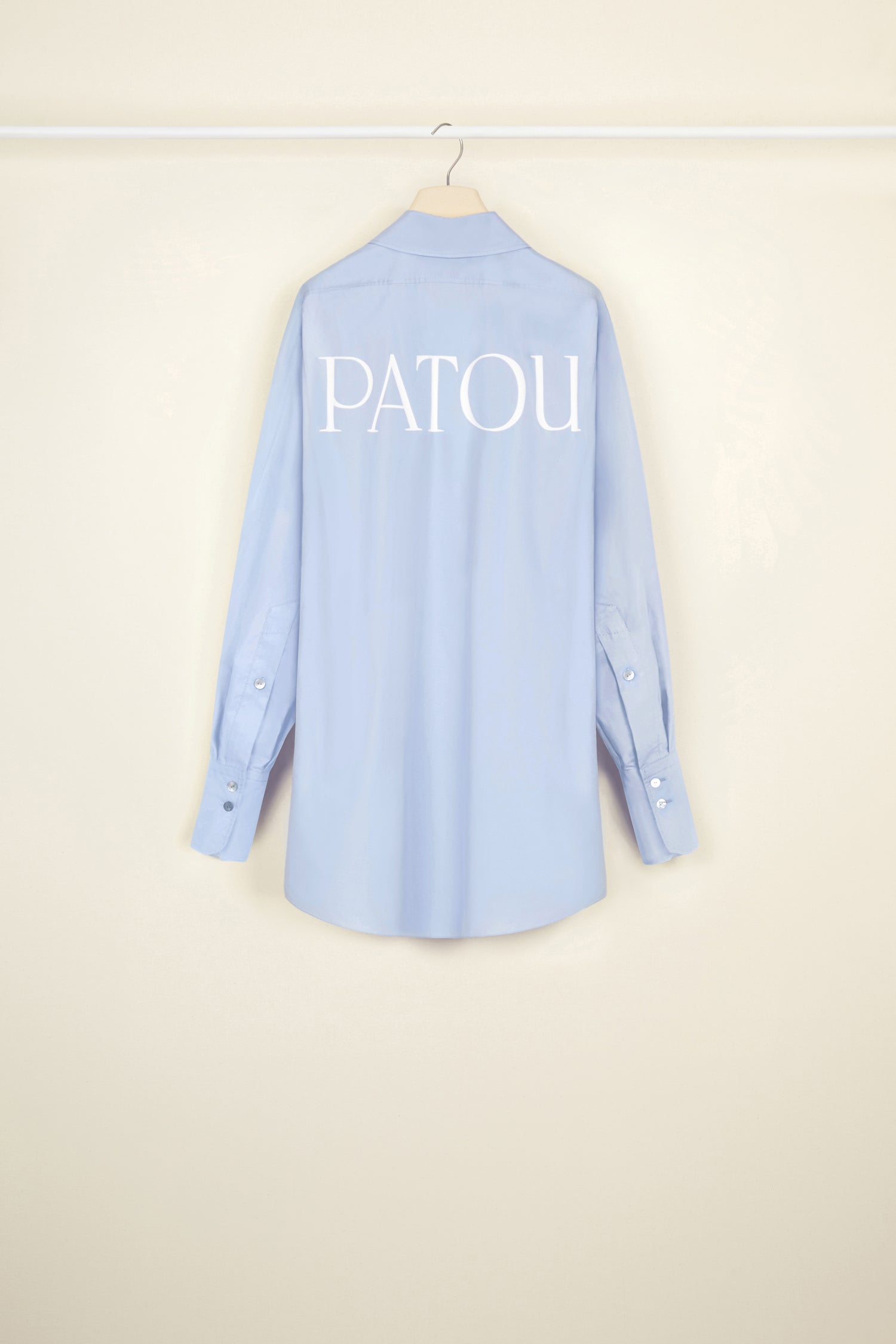 Patou - Mini shirt dress in organic cotton - Aurora - Layered or on its own, a new shape to make your own.Aurora light blue organic cotton poplin shirt dress. Short length. Loose silhouette. Shirt collar. Concealed button fastening with JP engraved buttons. Patou logo embroidered at the front. Signature curved seam at the back. Buttoned cuffs.
