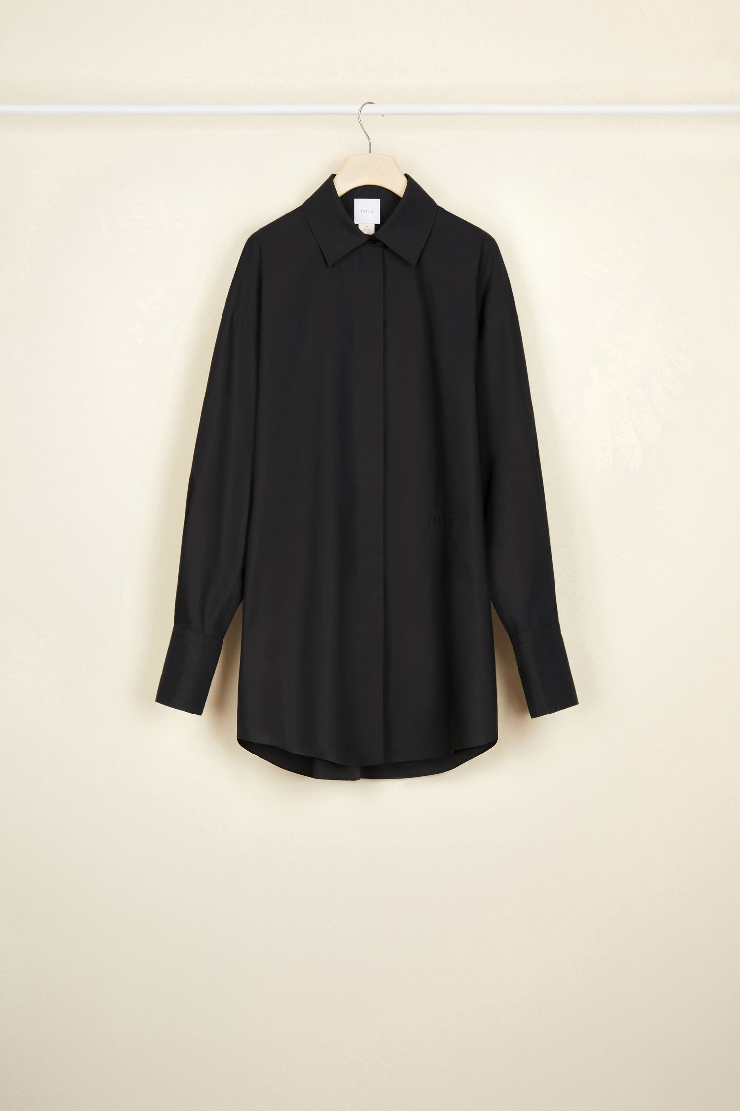 Patou - Mini shirt dress in organic cotton - Black - Layered or on its own, a new shape to make your own.Black organic cotton poplin shirt dress. Short length. Loose silhouette. Shirt collar. Concealed button fastening with JP engraved buttons. Patou logo embroidered at the front. Signature curved seam at the back. Buttoned cuffs.