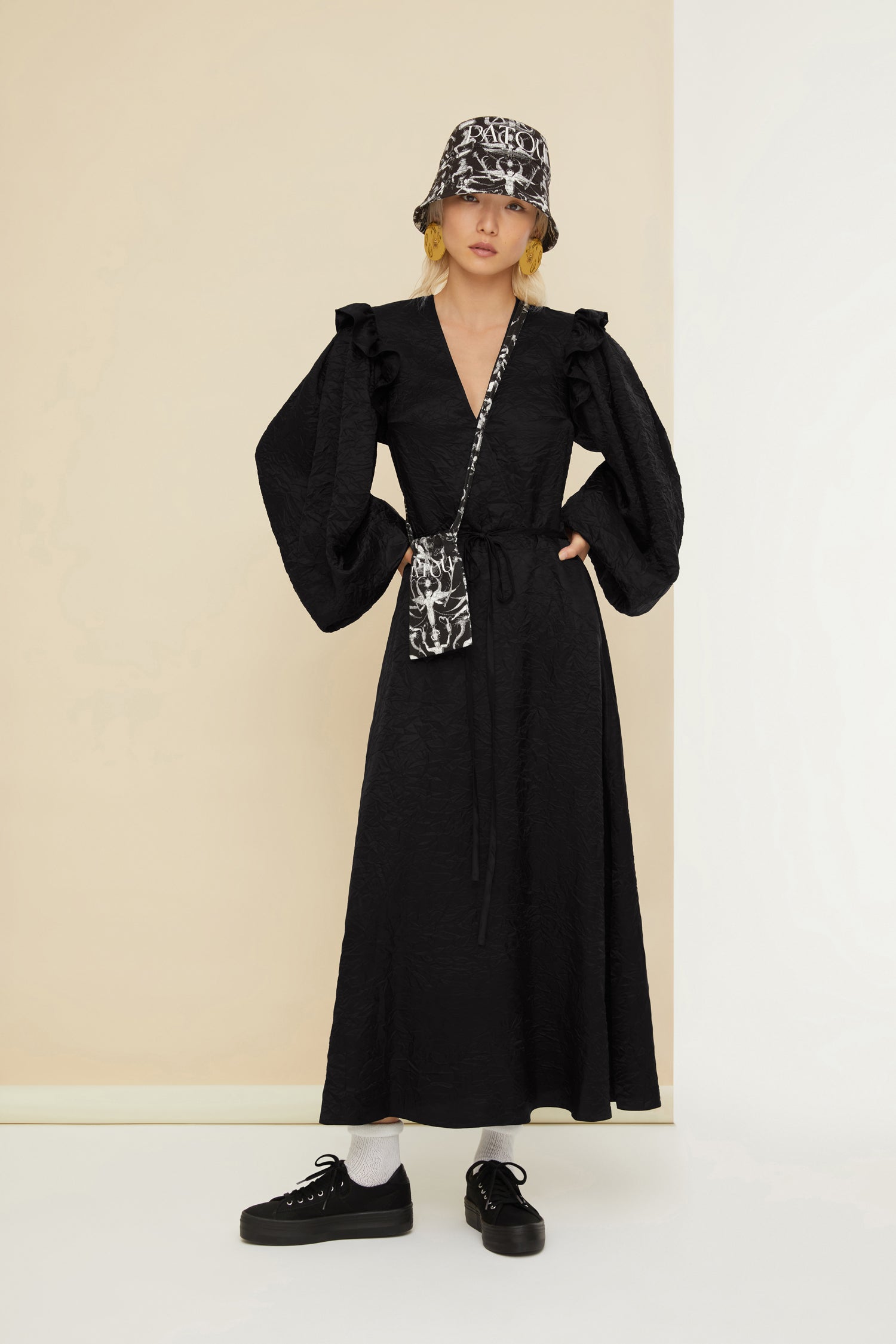 Patou - Robe longue décolletée en satin éco responsable - Black - Le satin froissé apporte fraîcheur et légèreté aux tenues de soirée. Robe en satin éco-responsable noir. Effet froissé. Longueur maxi. Buste croisé à col en V. Volants sur les épaules. Manches ballon à poignets élastiqués. Fine ceinture en tissu à la taille