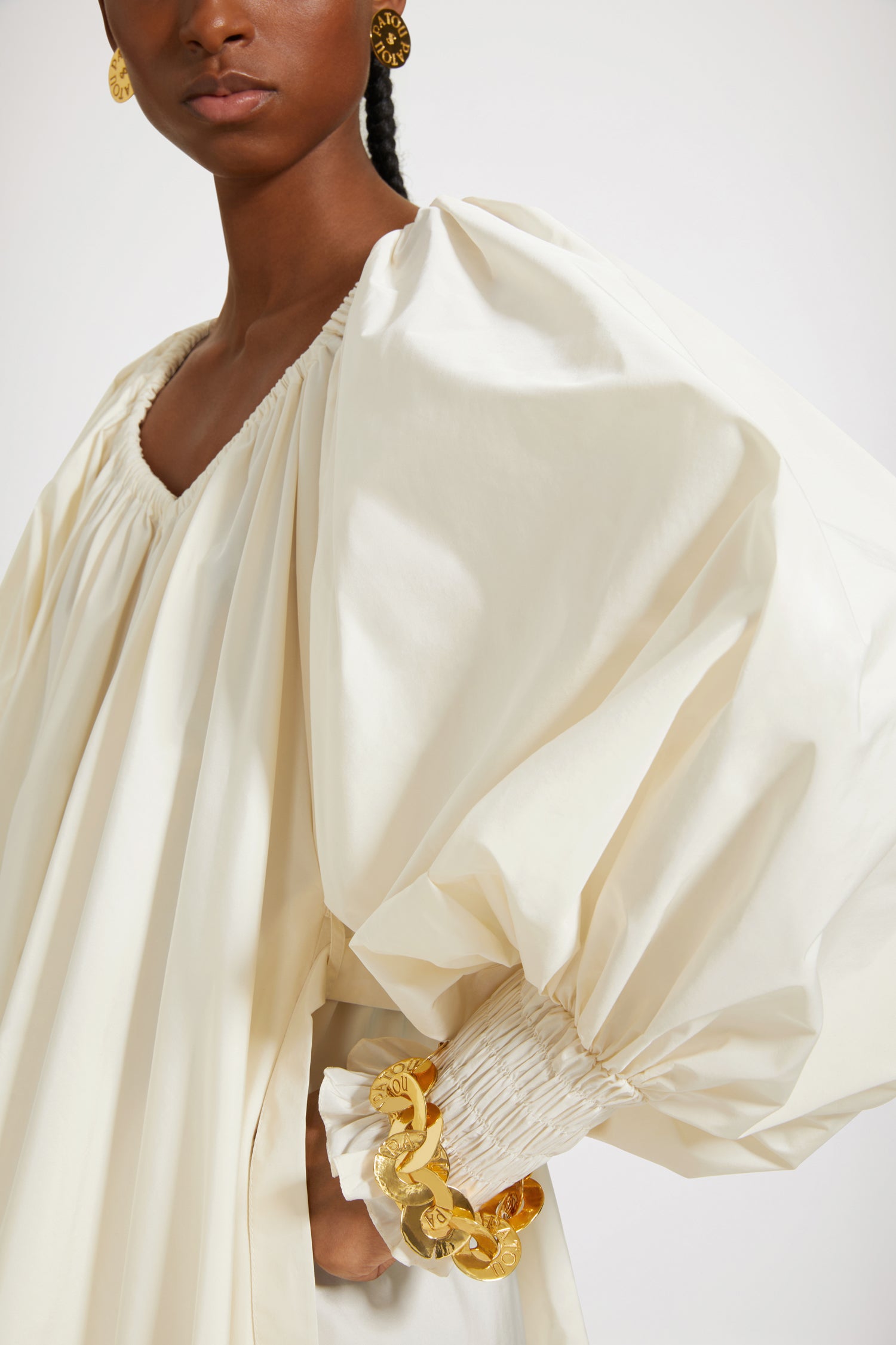 Patou - Maxi cocktail dress in recycled faille - Ivory - An elaborate cocktail of high volume and high spirits.Ivory recycled polyester faille dress. Maxi length. Tiered construction. Asymmetric silhouette that is longer at the back. Elasticated neckline that can be worn off the shoulders. High-volume sleeves with smocked cuffs. Belt at the waist. Pockets at the sides.This cut is oversized but we advise you to take your usual size.Spring-Summer 2023 Show - Look #12
