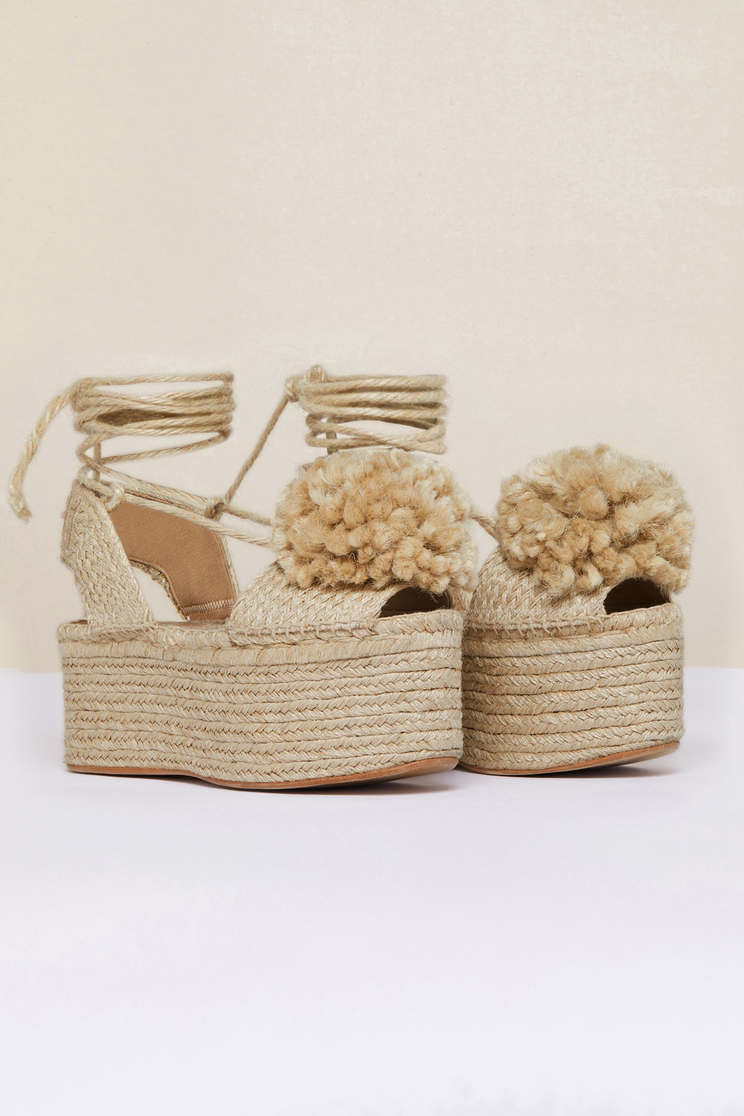 Patou - Espadrillas a zeppa con pompon - Vanilla - Le espadrillas puntano in alto. Espadrillas in juta color vaniglia con suole a zeppa. Pompon e lacci monocromatici. Logo Patou ricamato sul cinturino posteriore.