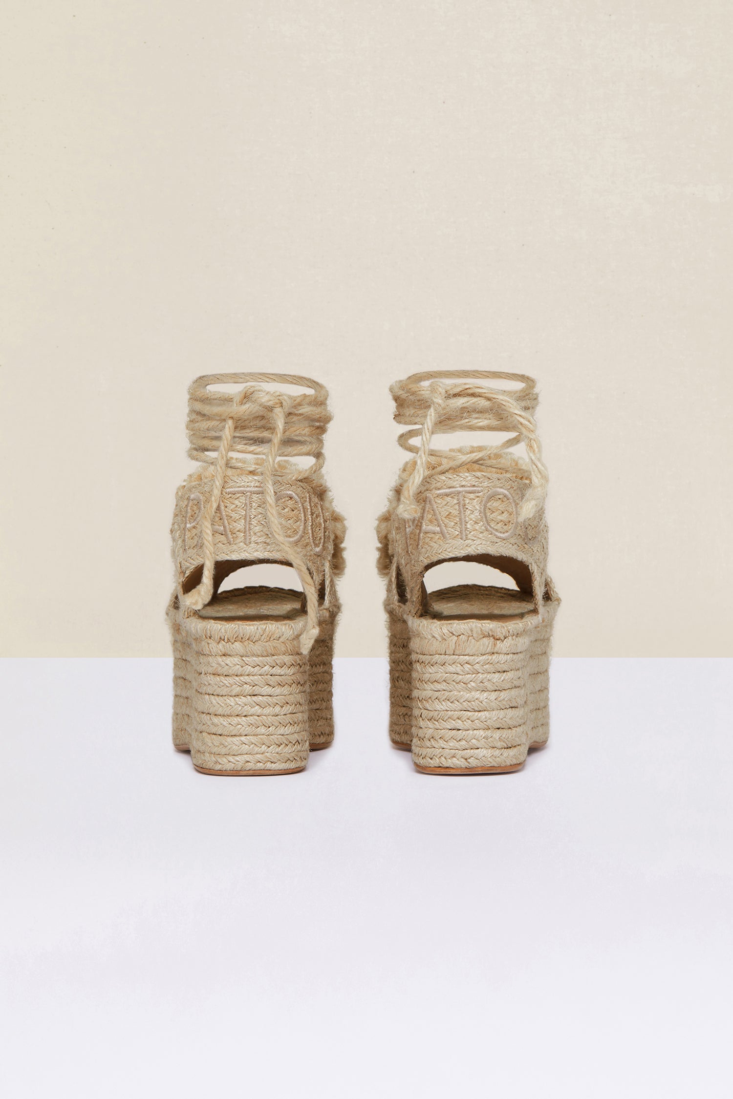 Patou - Espadrillas a zeppa con pompon - Vanilla - Le espadrillas puntano in alto. Espadrillas in juta color vaniglia con suole a zeppa. Pompon e lacci monocromatici. Logo Patou ricamato sul cinturino posteriore.