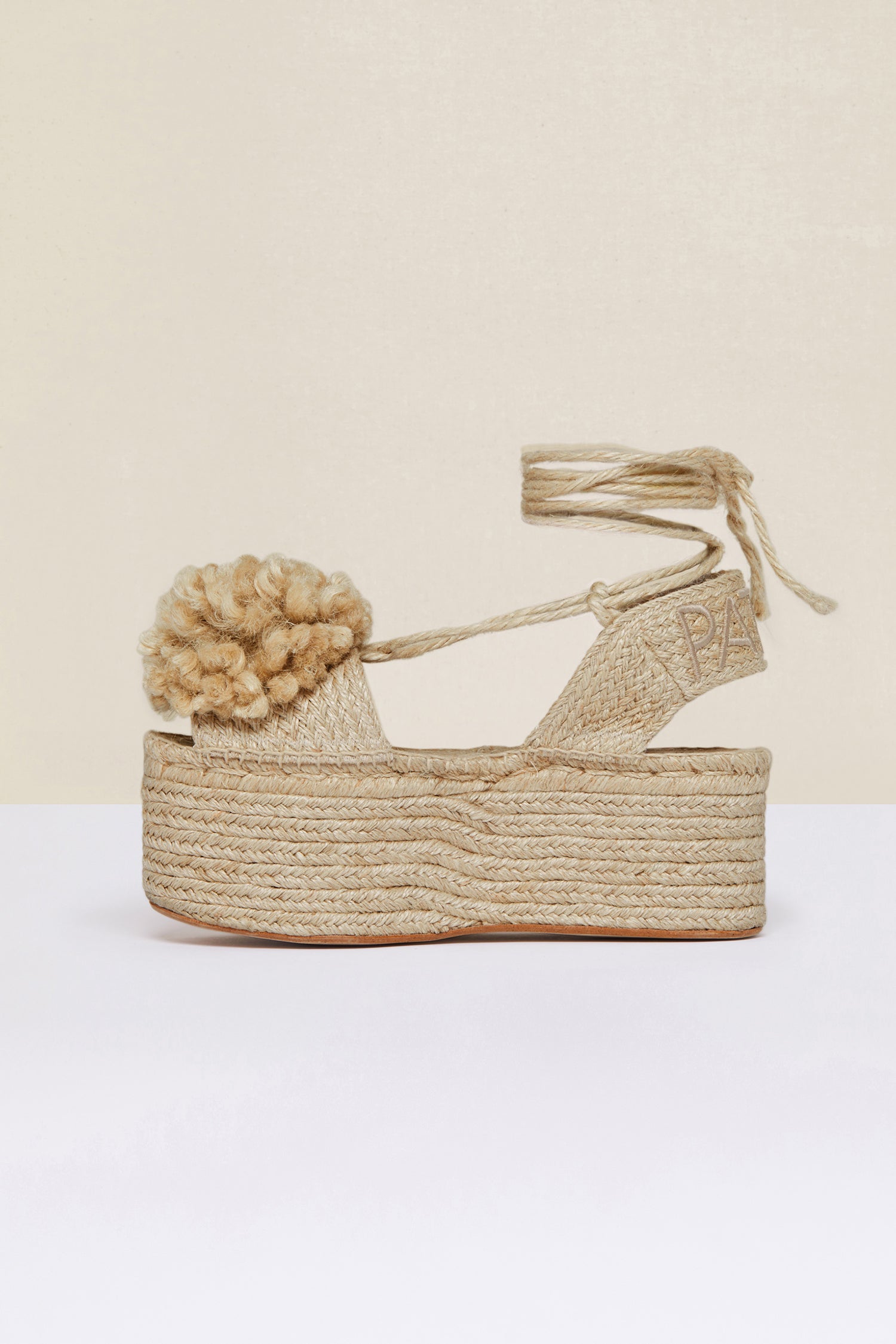 Patou - Espadrillas a zeppa con pompon - Vanilla - Le espadrillas puntano in alto. Espadrillas in juta color vaniglia con suole a zeppa. Pompon e lacci monocromatici. Logo Patou ricamato sul cinturino posteriore.