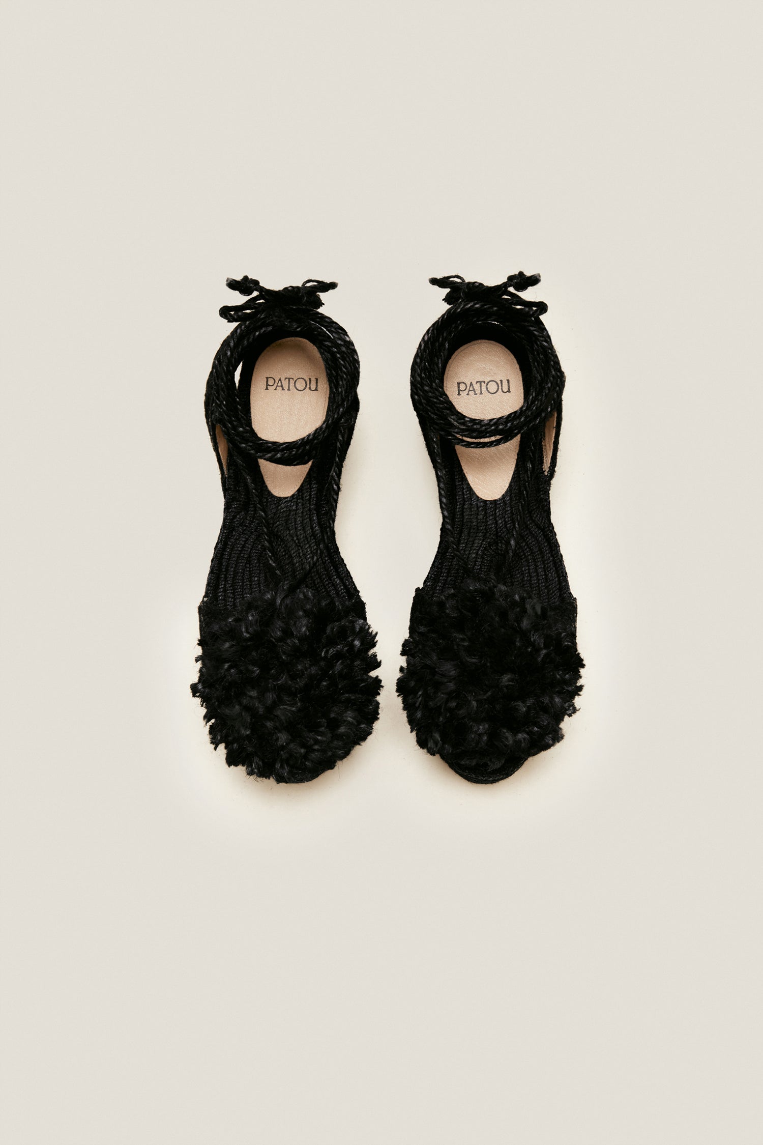 Patou - Plateau-Espadrilles mit Pompon - Black - Erhabene Espadrilles. Schwarze Jute-Espadrilles mit gerader Plateausohle. Farblich abgestimmte Pompons und Fesselriemchen. Slingback-Riemen mit aufgesticktem Buchstabenlogo.