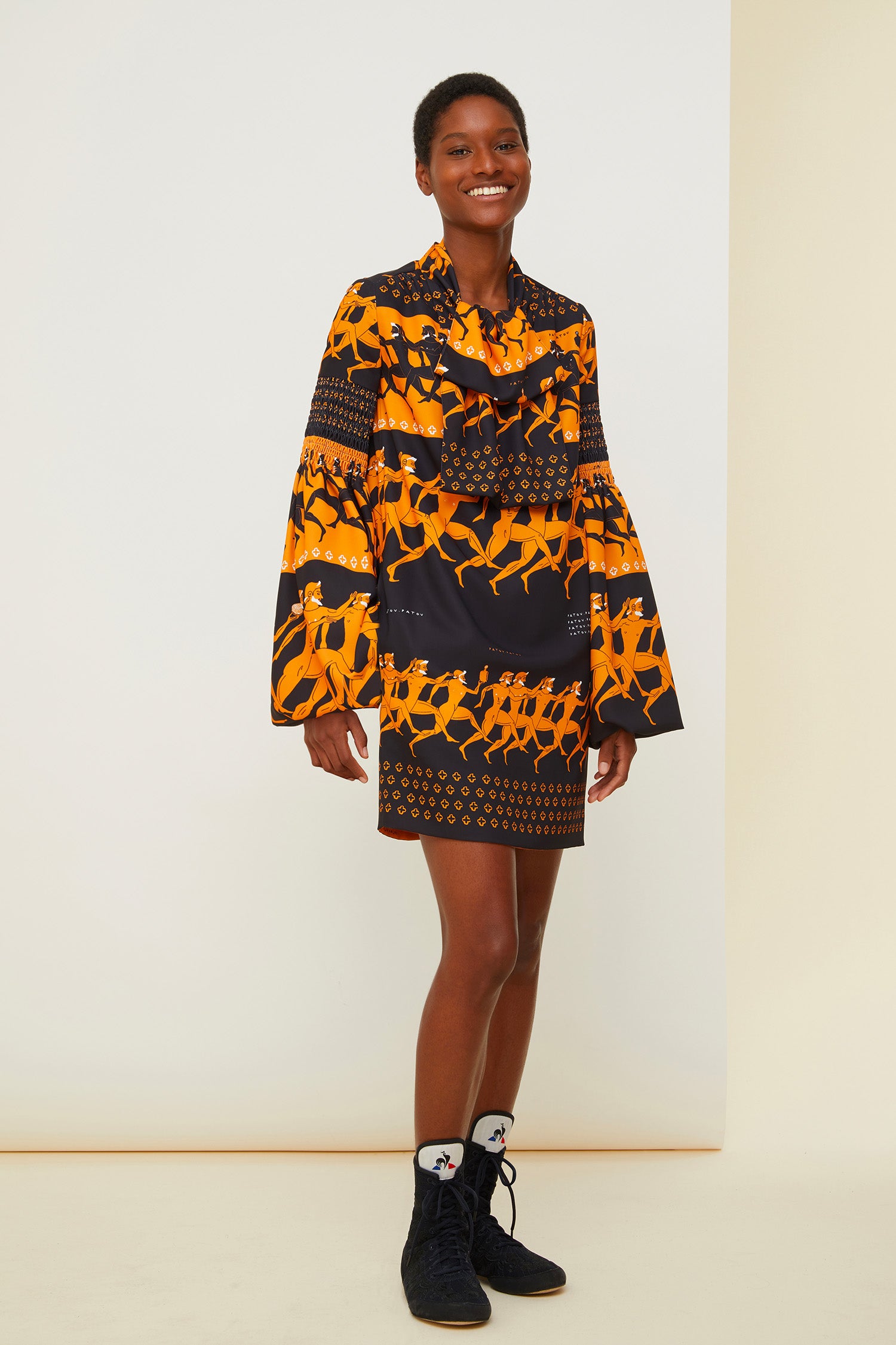 Patou - Vestito corto stampato con collo lavallière - Sport Education Print - Pagoda e lavallière: il fascino dei dettagli couture.Vestito corto in poliestere con collo lavallière. Disegni ispirati alla Grecia antica sul tema dell'educazione sportiva con riferimenti agli elementi iconici della storia Patou. Maniche a pagoda. Dettagli nido d'ape su spalle, maniche e collo. Tasche laterali nascoste. Chiusura con cerniera. Interamente foderato.