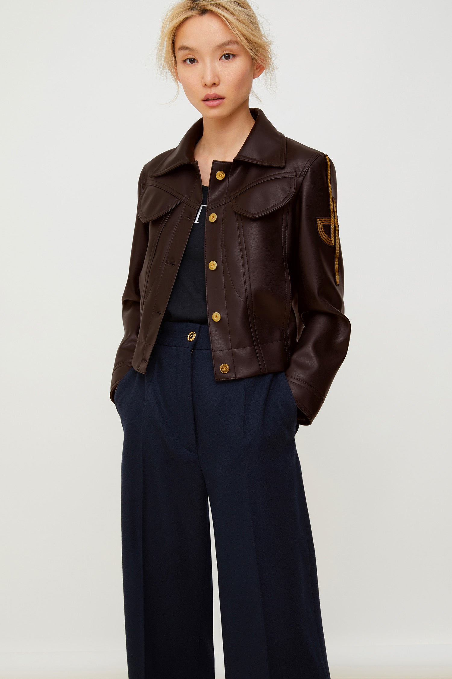 Patou - Veste en faux cuir à logo brodé - Havana - Le perfecto plus que parfait !Veste courte en faux cuir noir en matière synthétique à surpiqûres. Logo JP revisité brodé sur la manche gauche. Fermeture par boutons dorés gravés JP. Deux poches à rabat sur la poitrine, deux poches latérales. Pattes boutonnées à la ceinture et aux poignets.