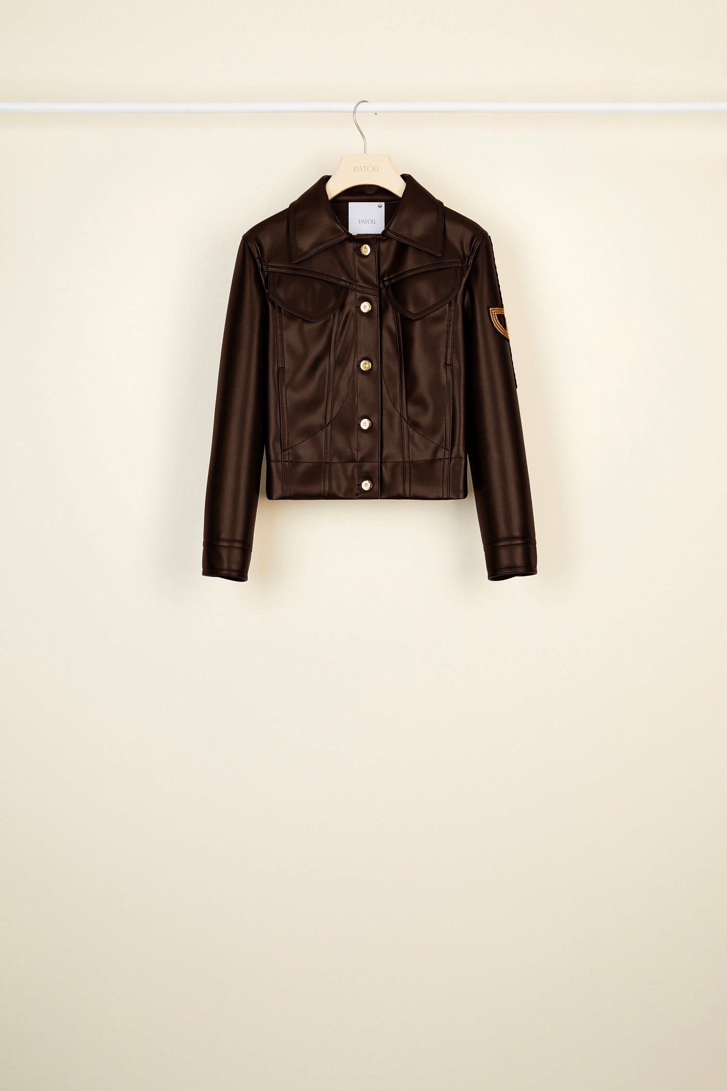 Patou - Veste en faux cuir à logo brodé - Havana - Le perfecto plus que parfait !Veste courte en faux cuir noir en matière synthétique à surpiqûres. Logo JP revisité brodé sur la manche gauche. Fermeture par boutons dorés gravés JP. Deux poches à rabat sur la poitrine, deux poches latérales. Pattes boutonnées à la ceinture et aux poignets.