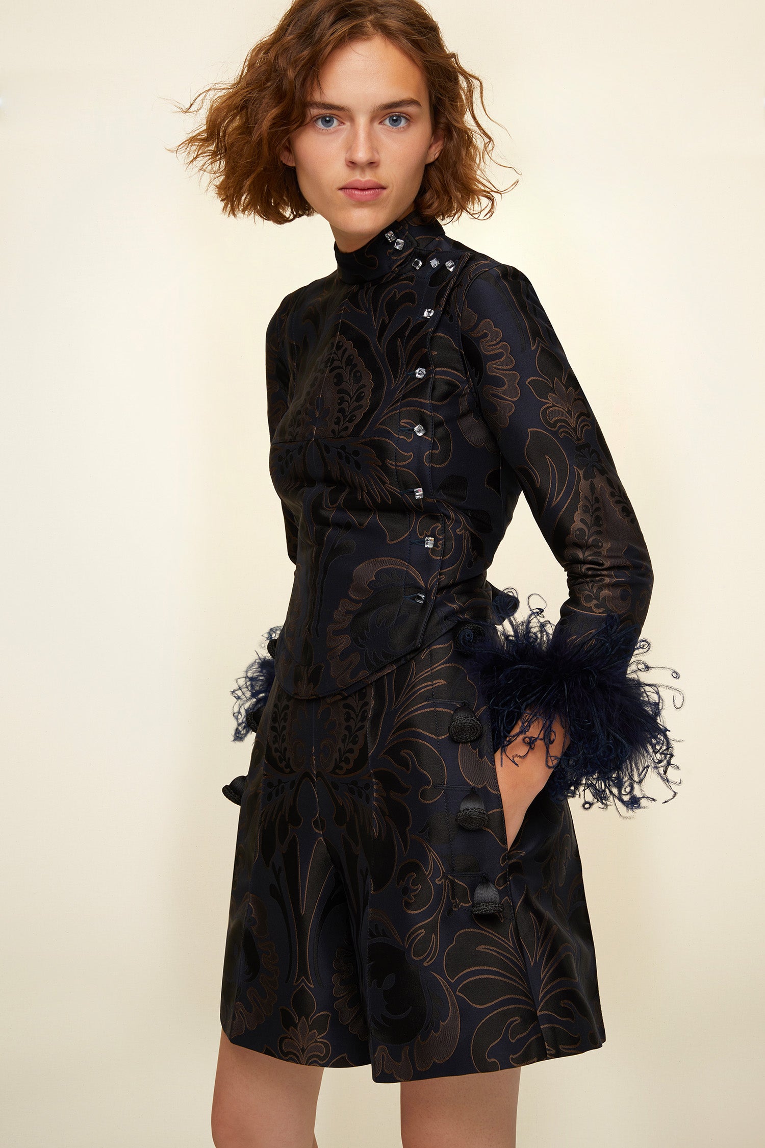 Patou - Feather-embellished silk brocade jacket - Navy Amber Print - Brocade is timeless, feathers are forever!Cropped navy and amber silk brocade jacket inspired by fencing uniforms. High collar and bejewelled buttons at the side. Removable ostrich feathers at the cuffs. Self-tie martingale at the back.