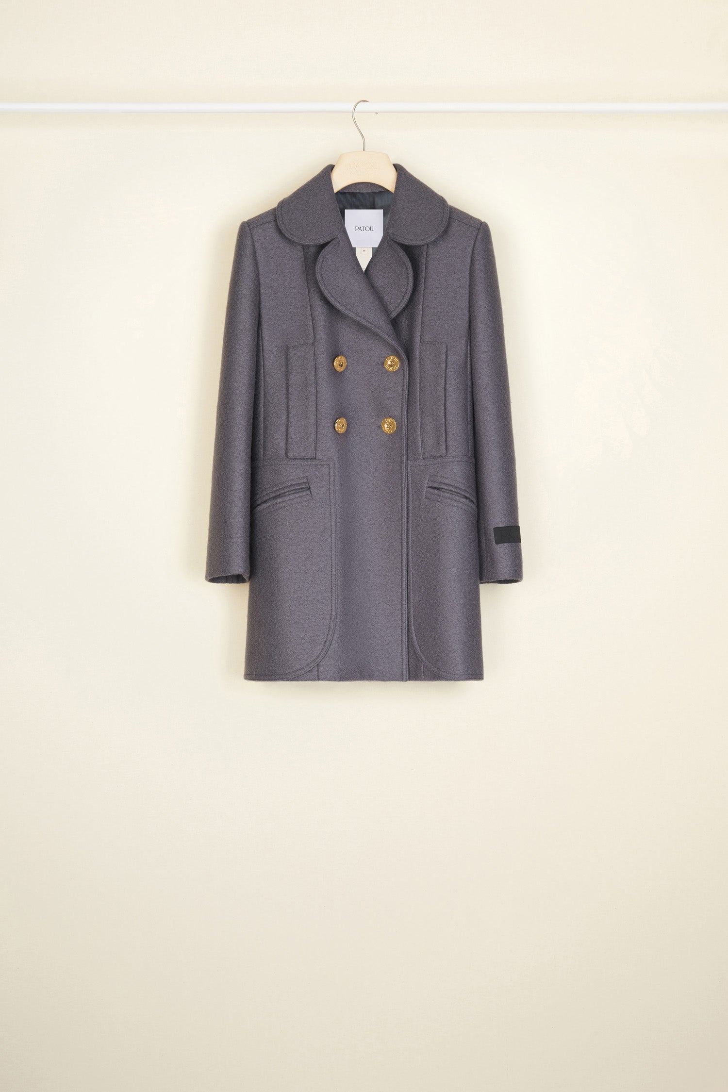 Patou - Longline double-breasted wool jacket - Storm - Seams and darts, the quiet couture details that scream Patou!  Grey boiled wool double-breasted jacket. Longline fitted silhouette with signature curved seams, darts at the waist and two vents at the back. Double rounded lapels. Gold-coloured buttons engraved with the Patou logo. Slightly cropped sleeves. Patou label on the left sleeve. Two mock pockets at the sides, two oversized patch pockets at the front.