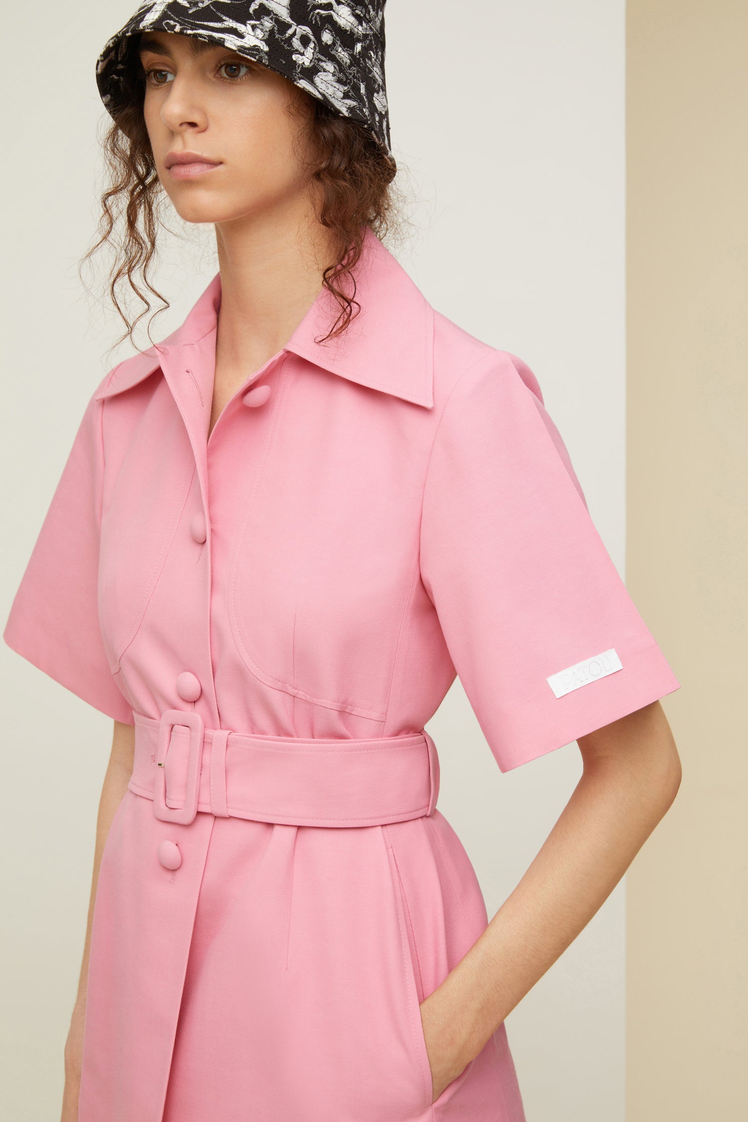 Patou - Belted short sleeve jacket in organic cotton and wool - Rose - Tailoring with a sweet tooth? Très Patou. Rose pink organic cotton and wool jacket. Spread collar. Short sleeves with Patou label on the left cuff. Button fastening with fabric covered buttons. Curved seams at the bust with chest darts. Wide adjustable belt with fabric-covered. Seam pockets at the sides. Single vent at the back.