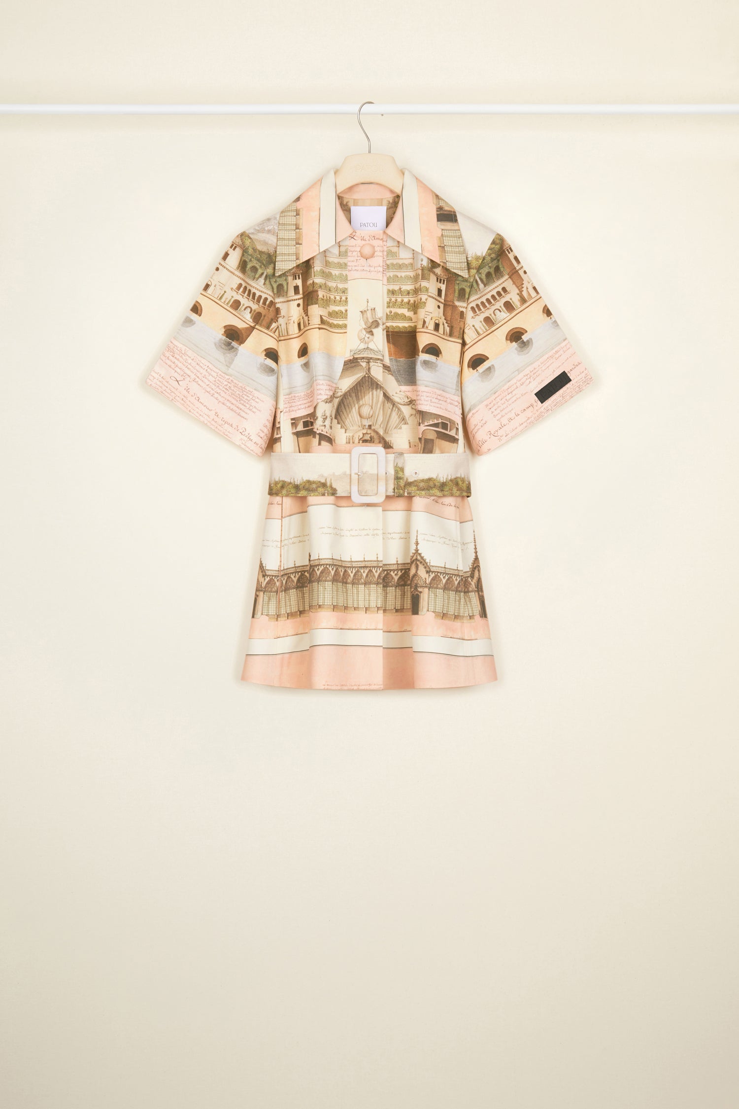 Patou - Belted short sleeve jacket in printed organic cotton and wool - Amour Island - Tailoring with a smile? Très Patou. Organic cotton and wool jacket featuring Jean-Jacques Lequeu's “Amour Island” print. Spread collar. Short sleeves with Patou label on the left cuff. Button fastening with fabric covered buttons. Curved seams at the bust with chest darts. Wide adjustable belt with fabric-covered. Seam pockets at the sides. Single vent at the back.